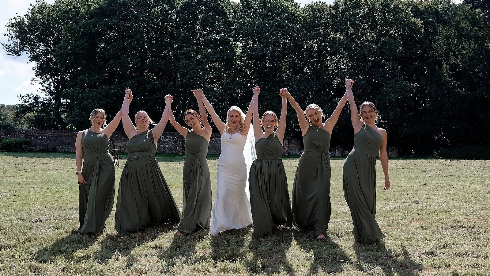 Bride and her bridesmaids in sage green dresses celebrating together on the morning of her Fitzleroi Barn wedding