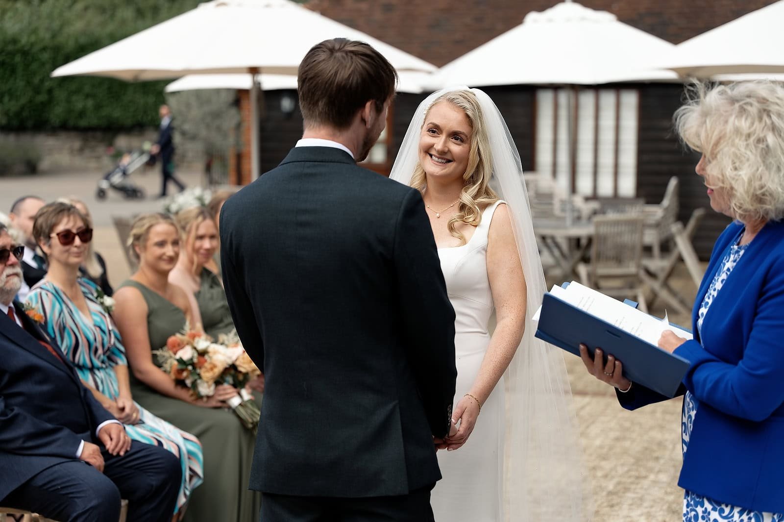 Bride and groom exchanging vows in the enclosed courtyard at Fitzleroi Barn