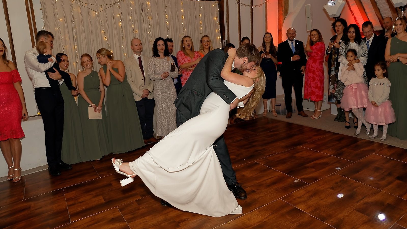Groom dipping his bride during their first dance at Fitzleroi Barn