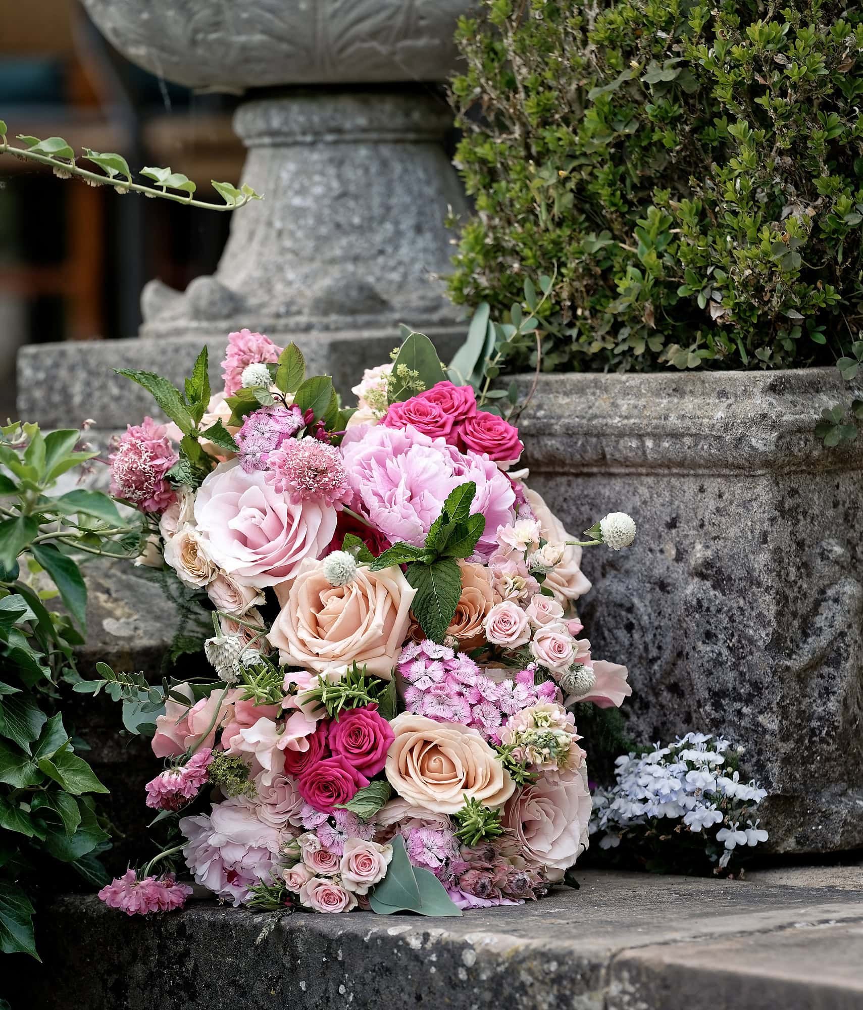 Bride's wedding bouquet of blush and champagne roses, pink peonies and sweet peas at South Lodge Hotel, Horsham