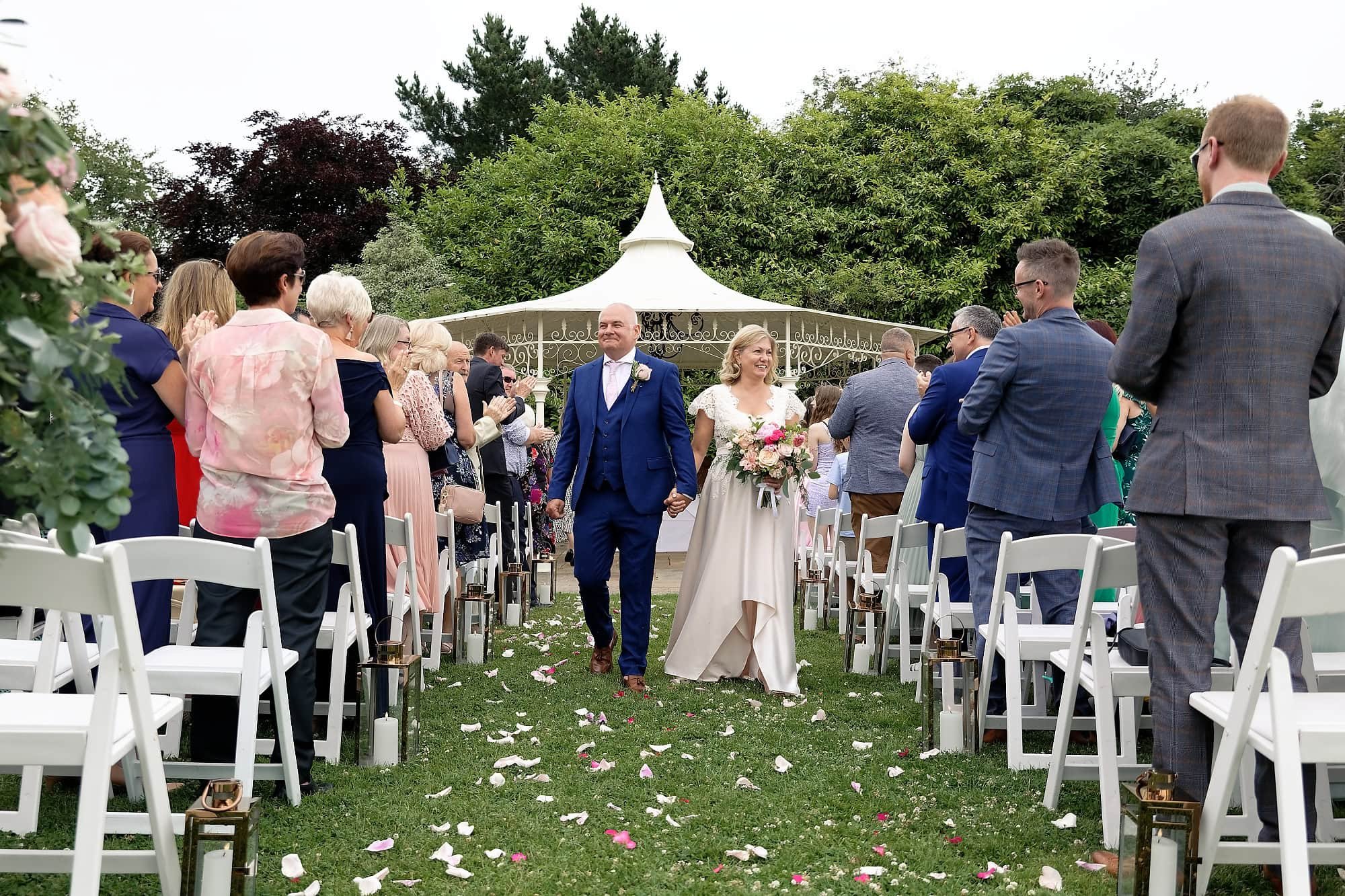 Bride and groom smiling as they walk back up the aisle after their ceremony at South Lodge Hotel, Horsham
