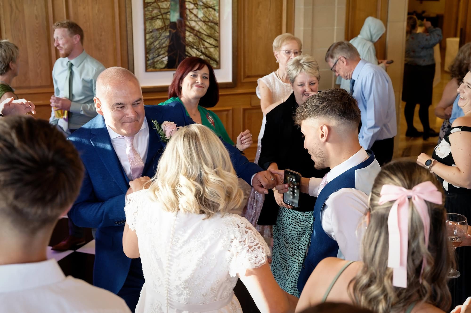 Bride, groom and son Joe celebrating on the dance floor with guests at their South Lodge wedding reception, Horsham