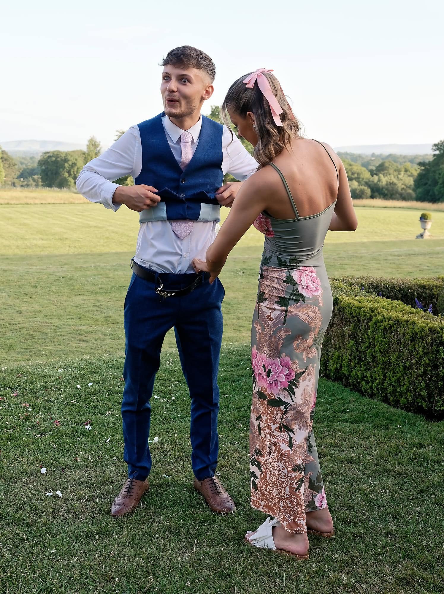 Groom's son Joe having his shirt tucked in by his partner on the dance floor at South Lodge wedding reception, Horsham