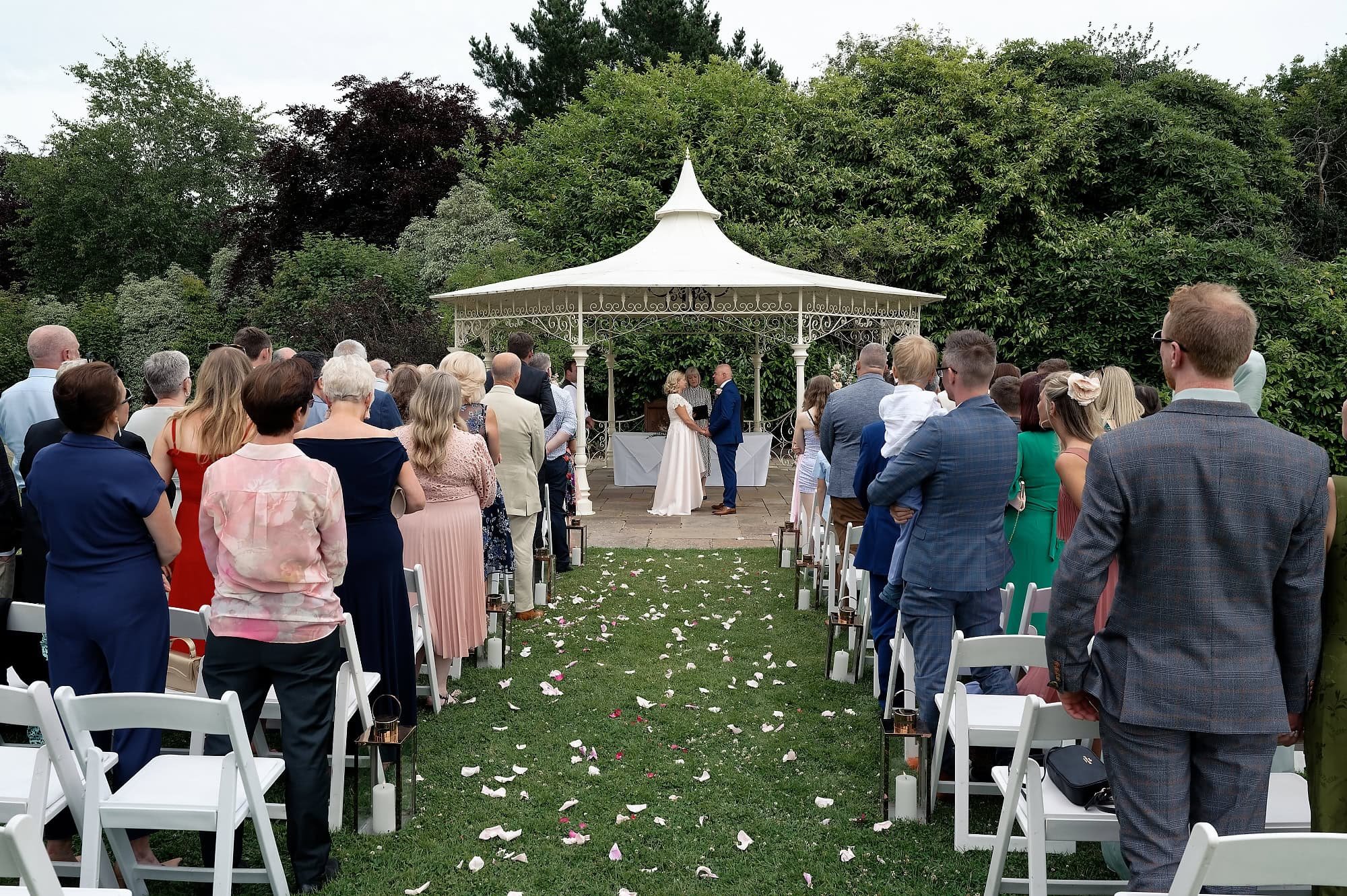 Bride and groom holding hands during their outdoor wedding ceremony at the Pavilion, South Lodge Hotel, Horsham