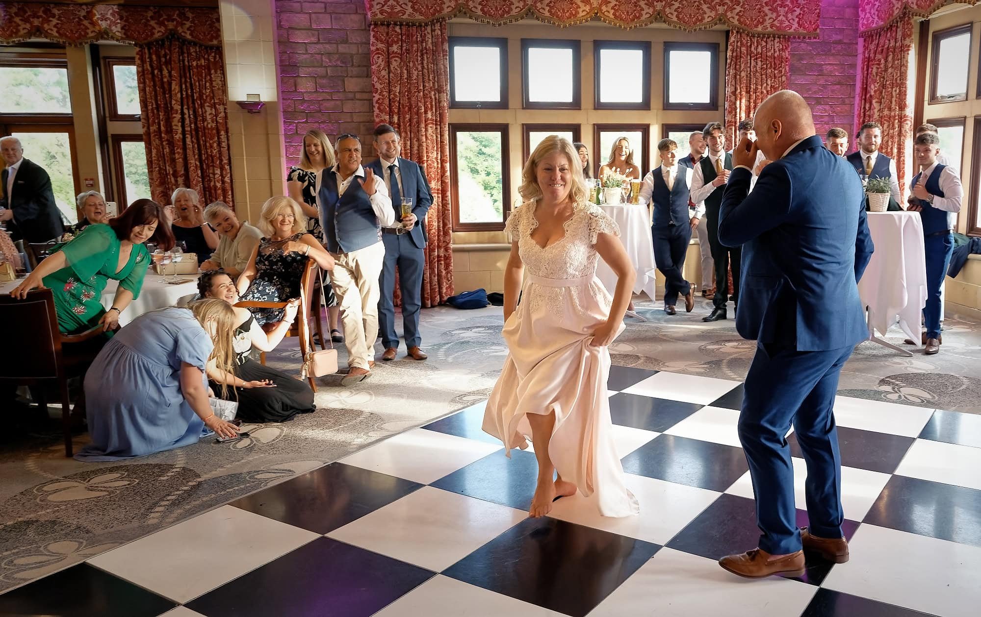 Bride and groom laughing and dancing together at the end of their first dance at South Lodge Hotel, Horsham