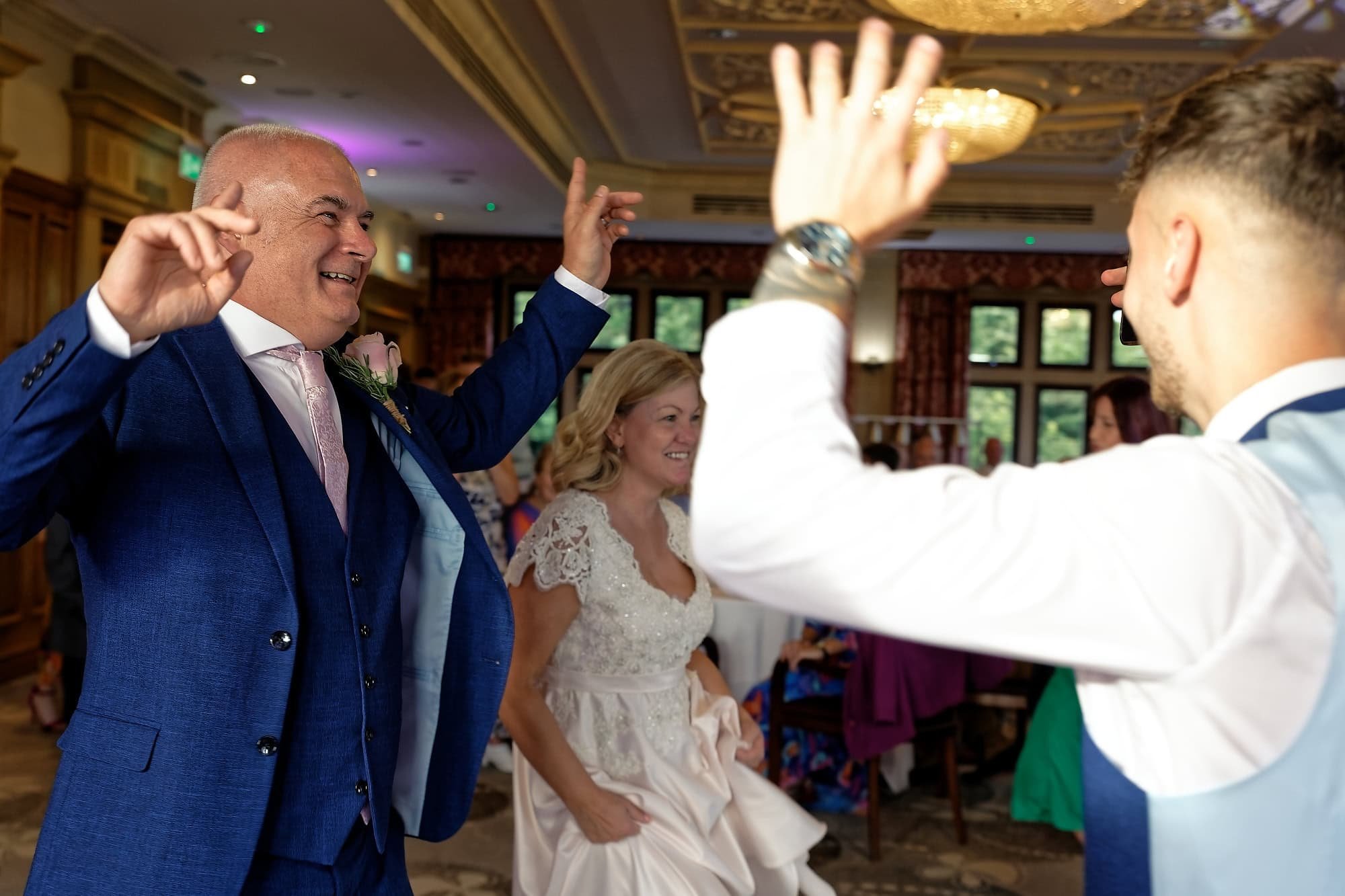 Groom dancing energetically on the dance floor at South Lodge Hotel wedding reception, Horsham, West Sussex