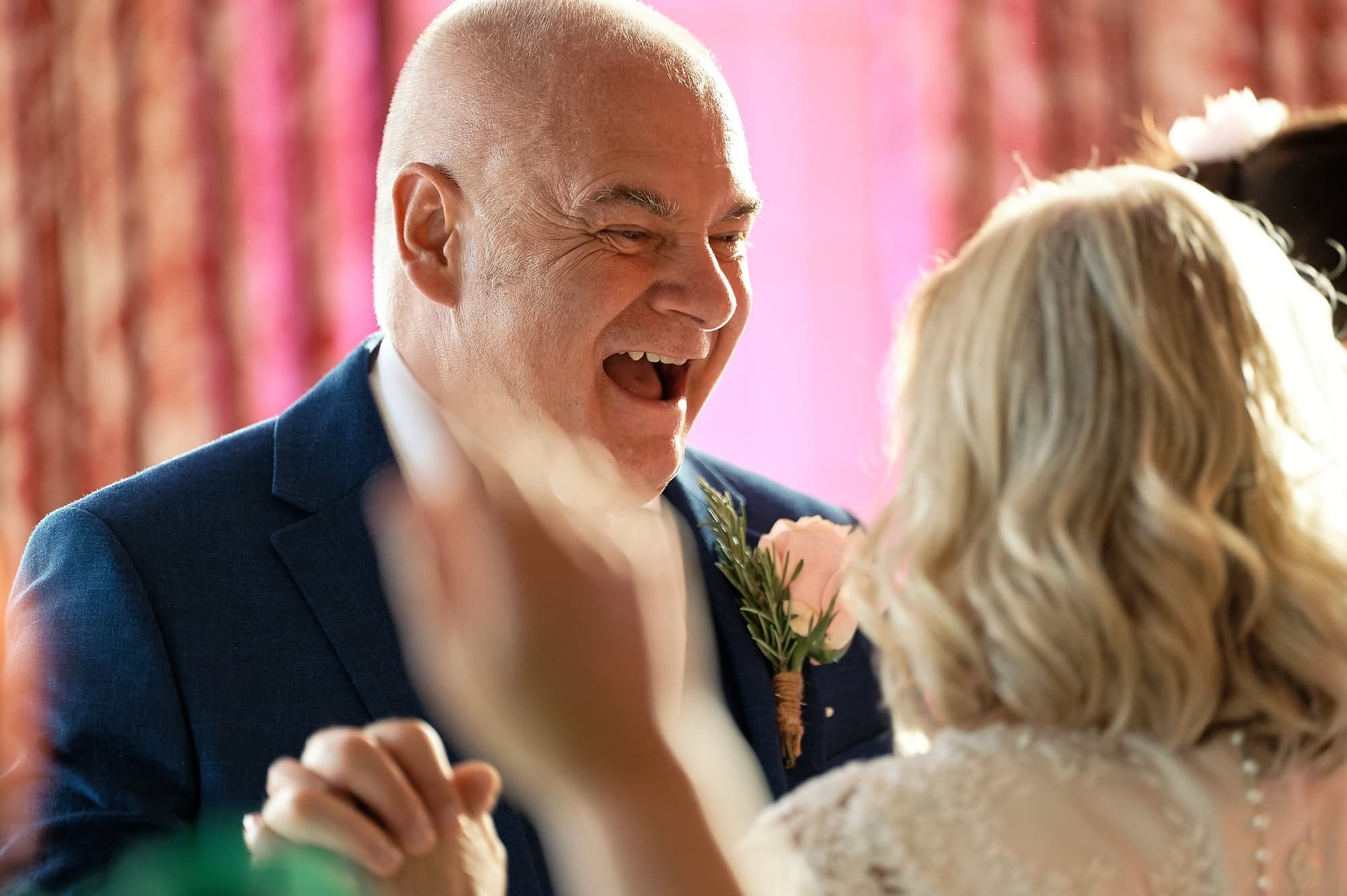 Groom laughing as he dances with the bride on the dance floor at South Lodge Hotel wedding reception, Horsham