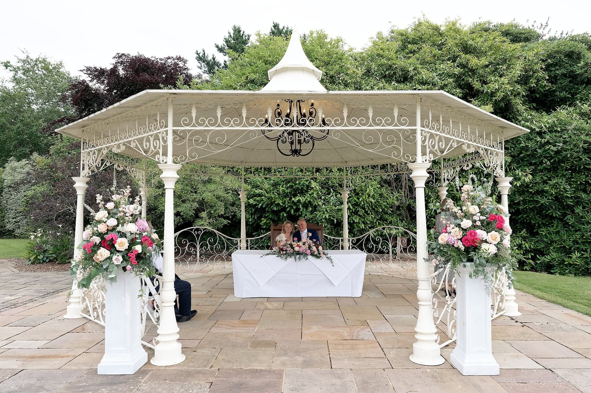 Bride and groom signing the register at the end of their outdoor ceremony at South Lodge Hotel, Horsham