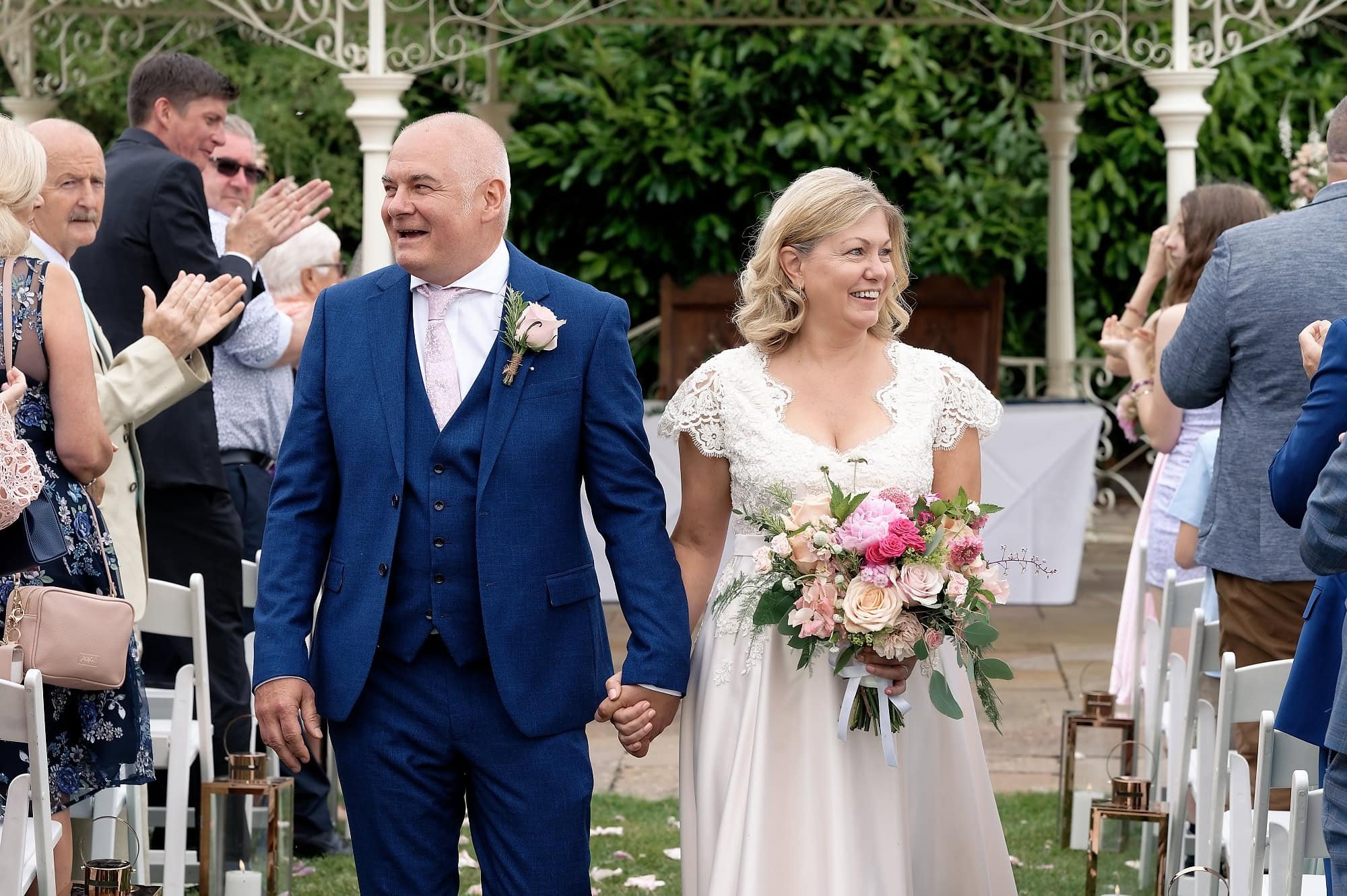 Bride and groom walking back up the aisle together at the end of their ceremony at South Lodge Hotel, Horsham