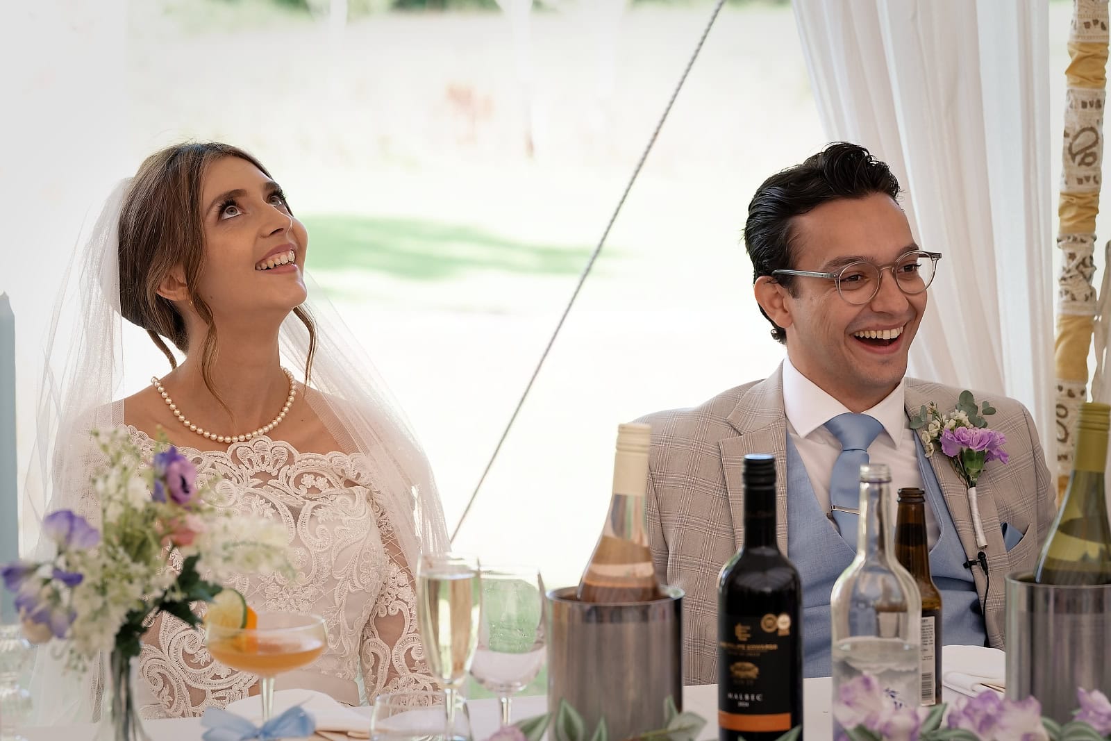 Bride and groom laughing during wedding speeches at Trading Boundaries Sussex