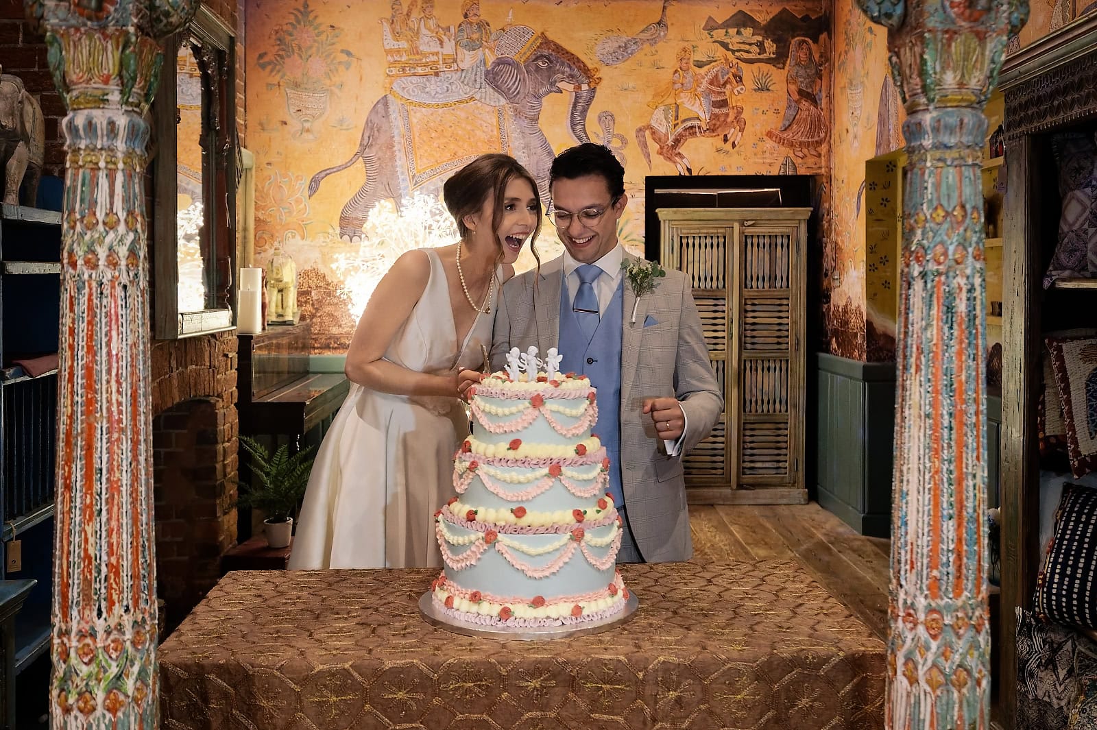 Bride and groom cutting colourful wedding cake at Trading Boundaries venue