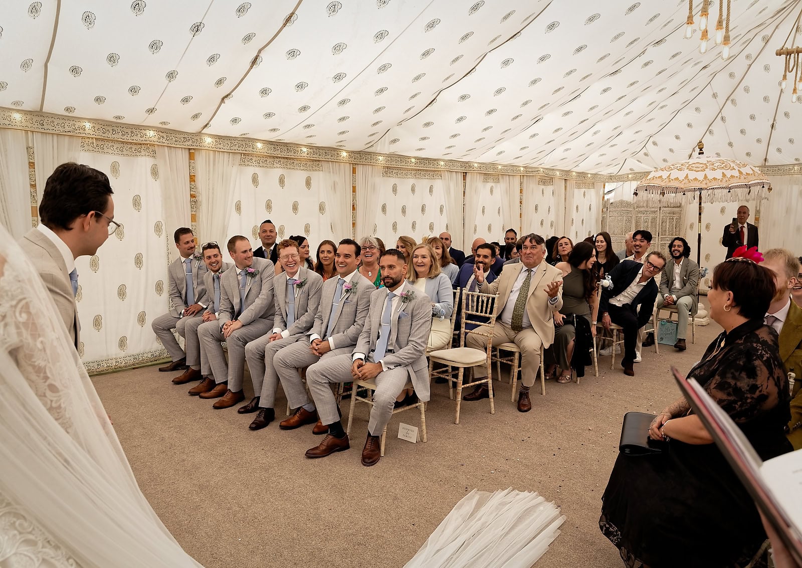 Guests smiling and laughing during wedding ceremony at Trading Boundaries wedding venue Sussex