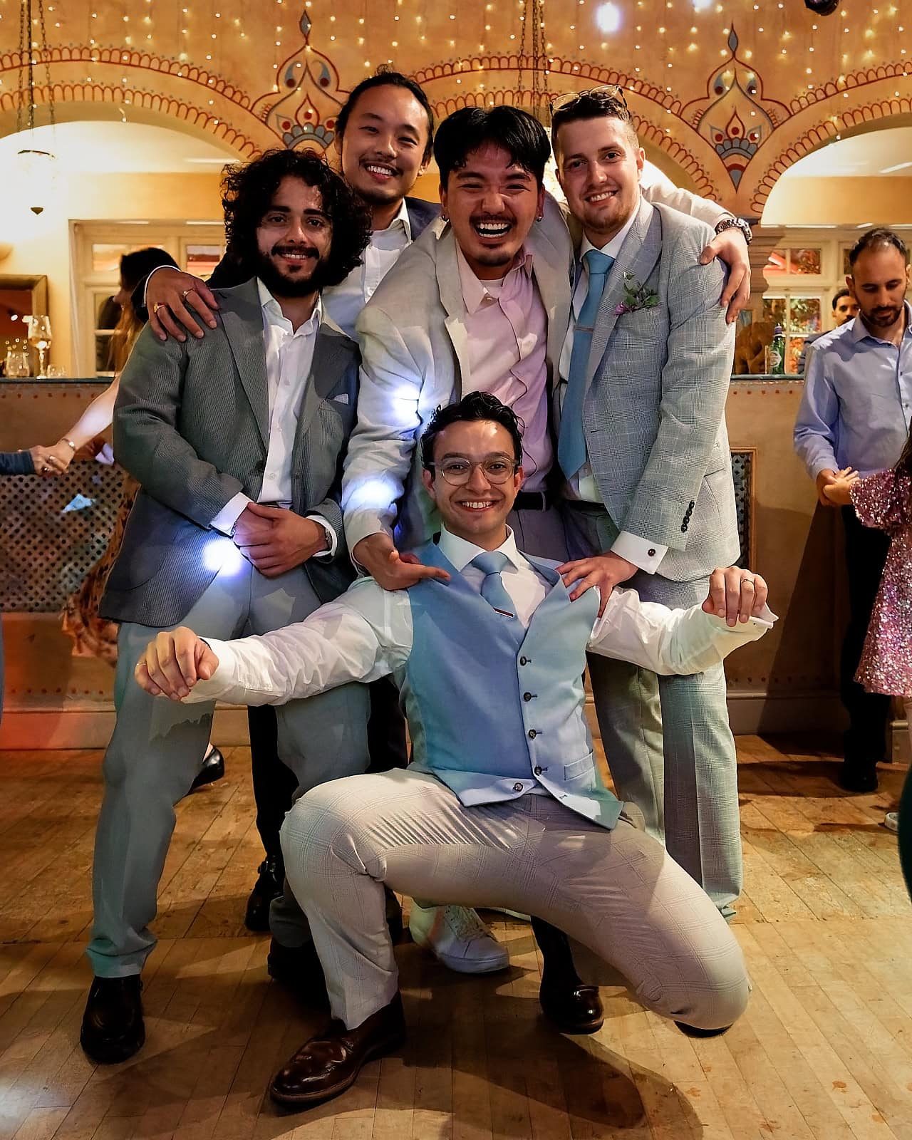 Groom celebrating with friends on dance floor at Trading Boundaries wedding