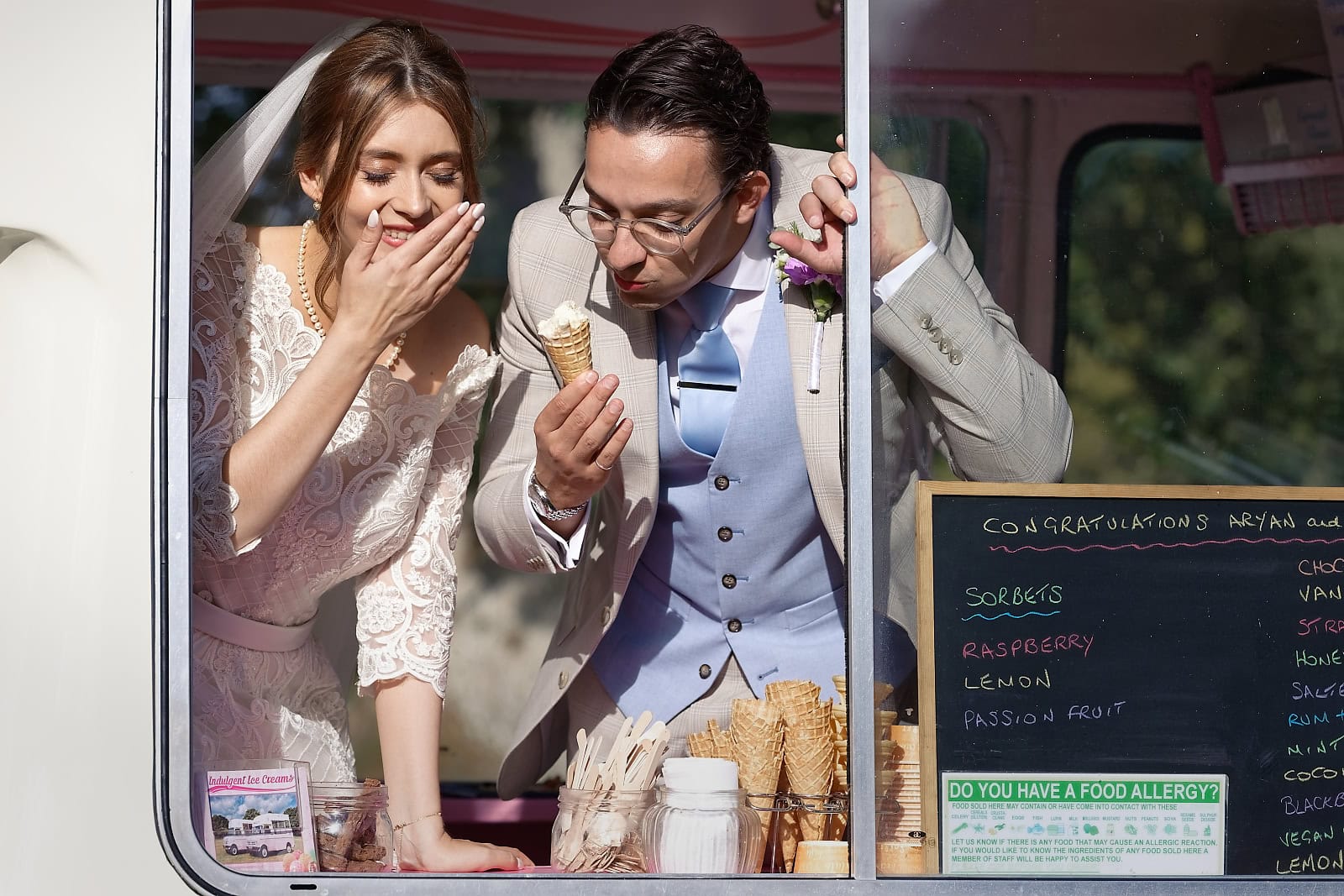 Bride and groom eating ice cream at vintage van during Trading Boundaries wedding Sussex