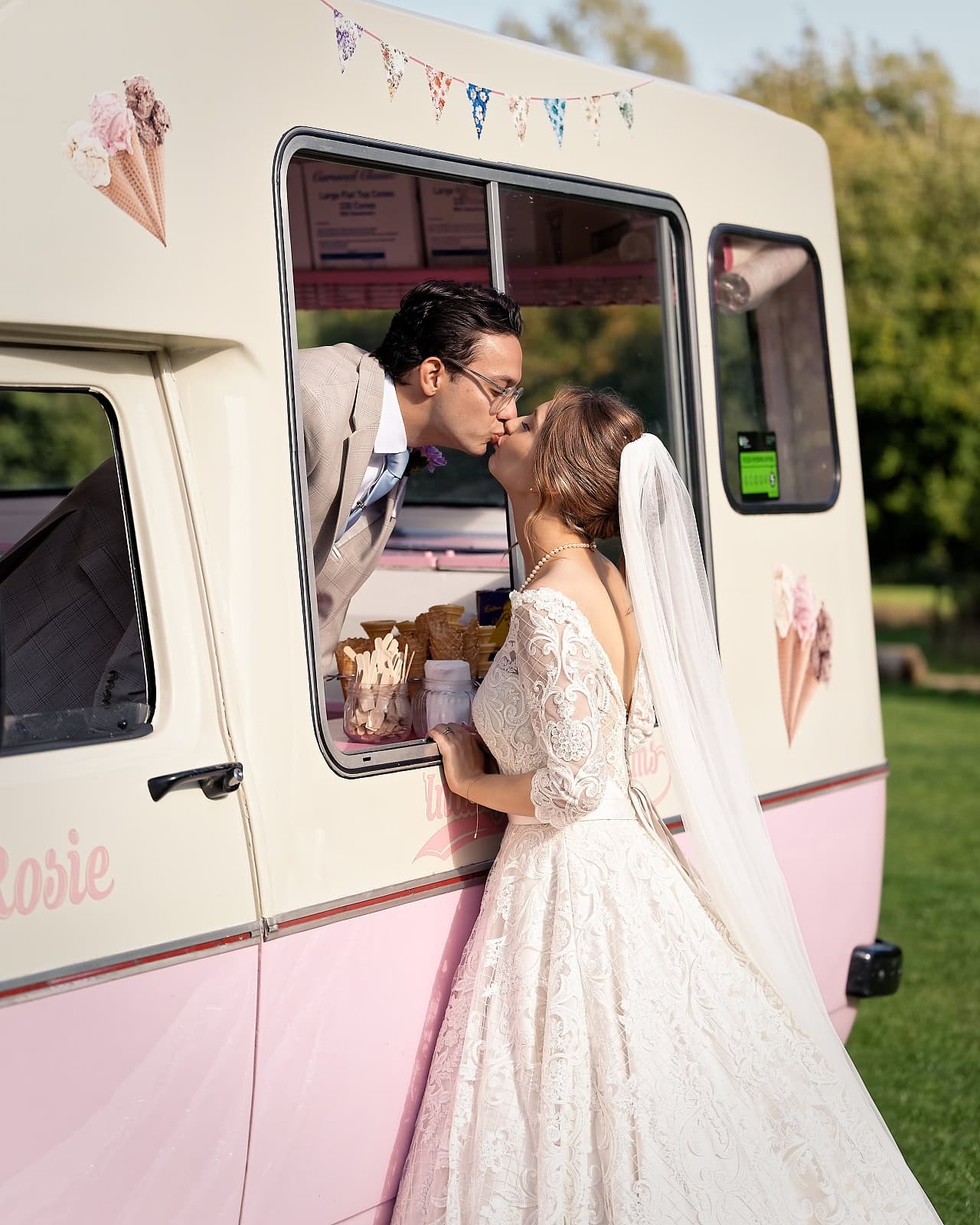 Bride and groom kissing at vintage ice cream van at Trading Boundaries wedding