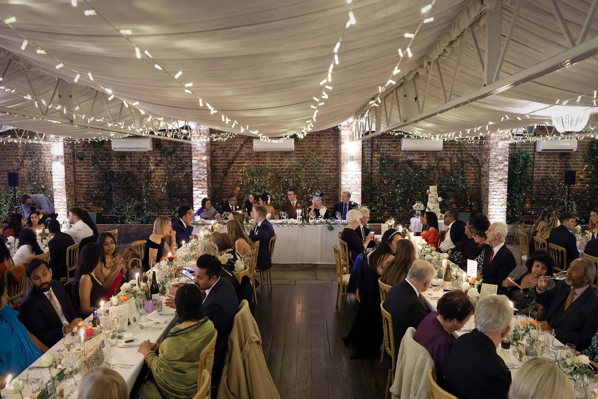 Wedding breakfast full room view in the Orangery at Northbrook Park wedding venue in Hampshire by Andy Kerr Photography