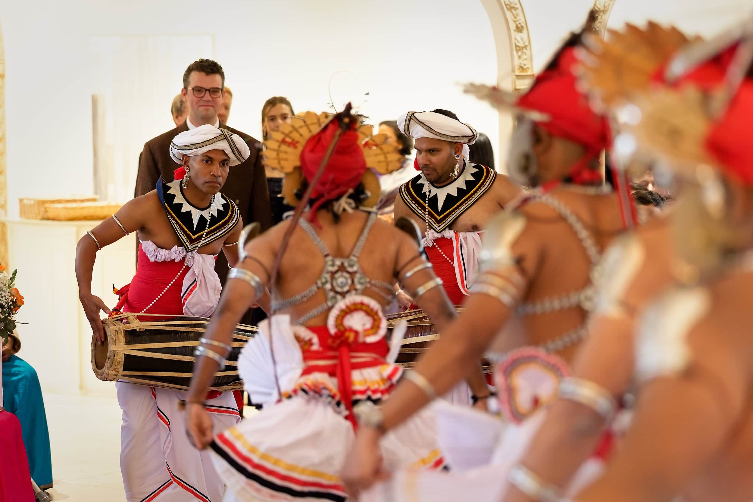 Traditional Sri Lankan dancers performing during the wedding ceremony in the Vine Room at Northbrook Park wedding venue in Hampshire by Andy Kerr Photography