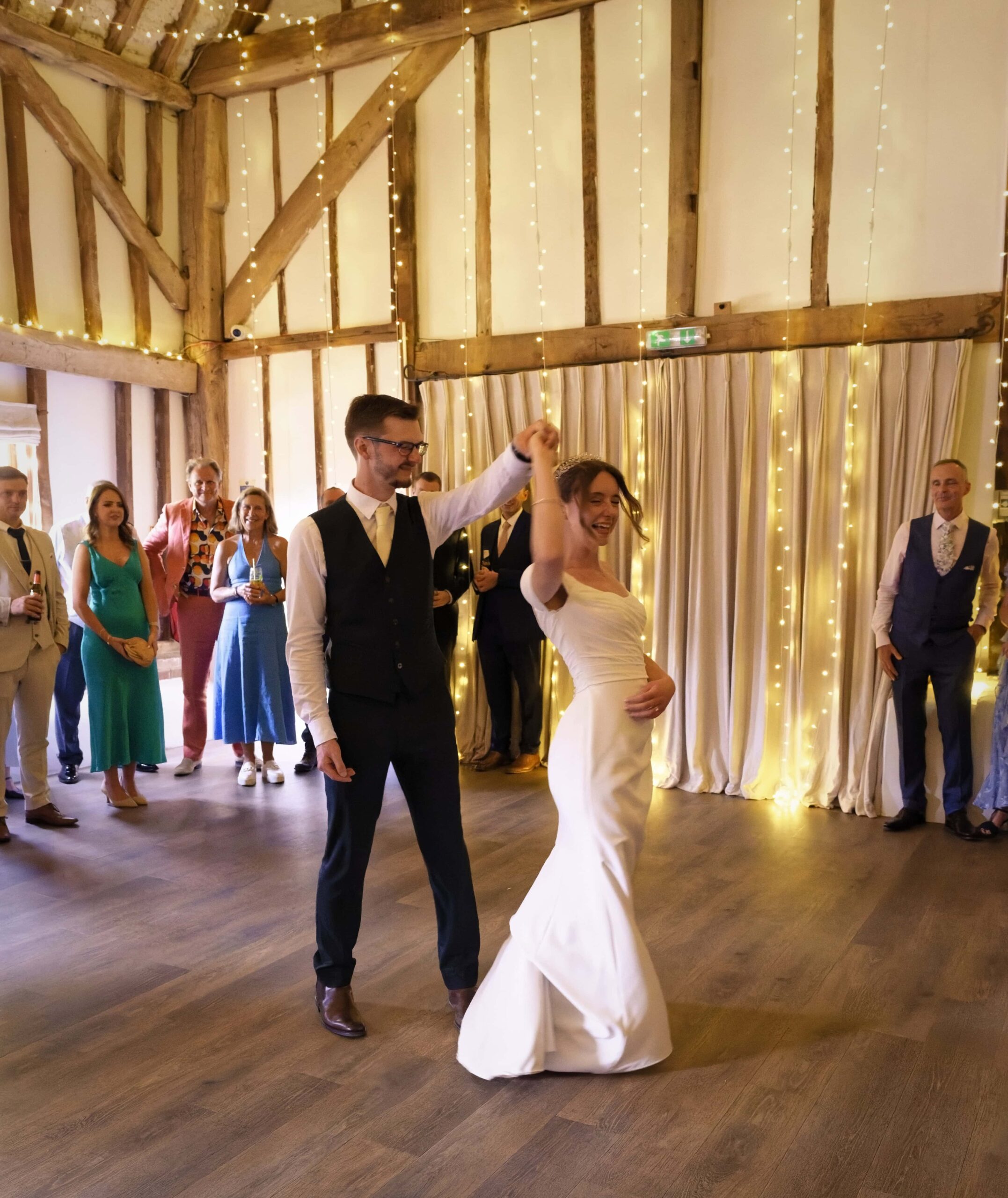 Fitzleroi Barn wedding photographer photo of the newlyweds' first dance twirl in the barn