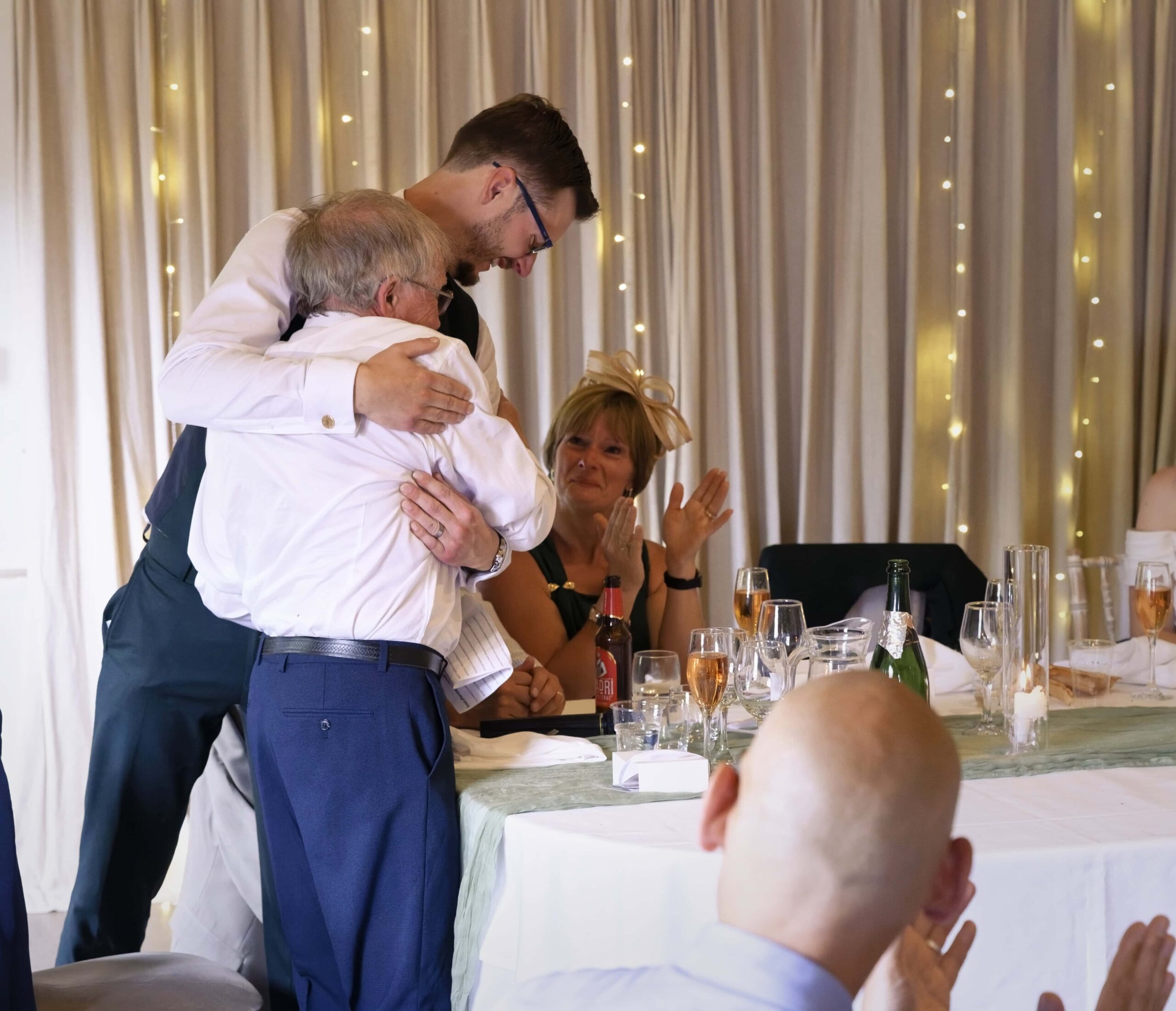 Fitzleroi Barn wedding photographer photo of the groom hugging his Best Man during the reception speeches