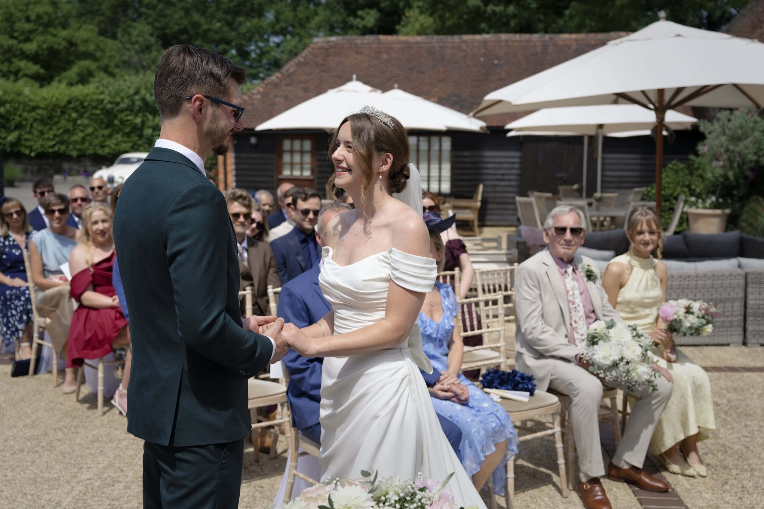 Fitzleroi Barn wedding photographer image of the couple exchanging vows during their outdoor ceremony