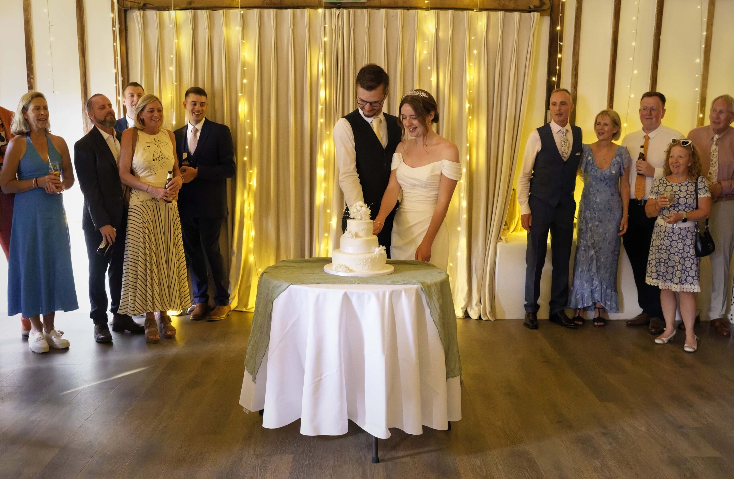 Fitzleroi Barn wedding photographer capturing the couple cutting their wedding cake at the reception