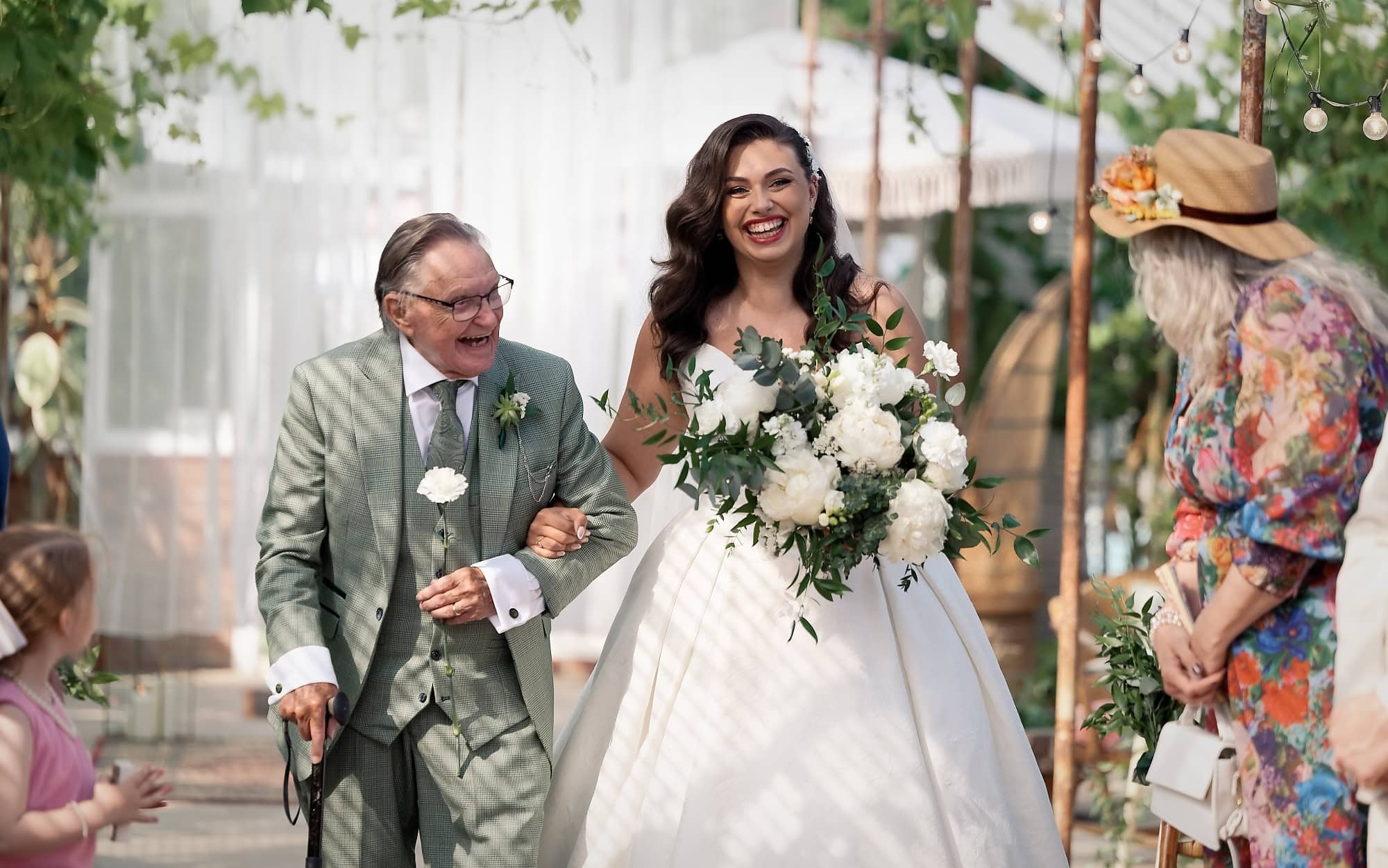 Bride laughing with her grandad moments before walking down the aisle
