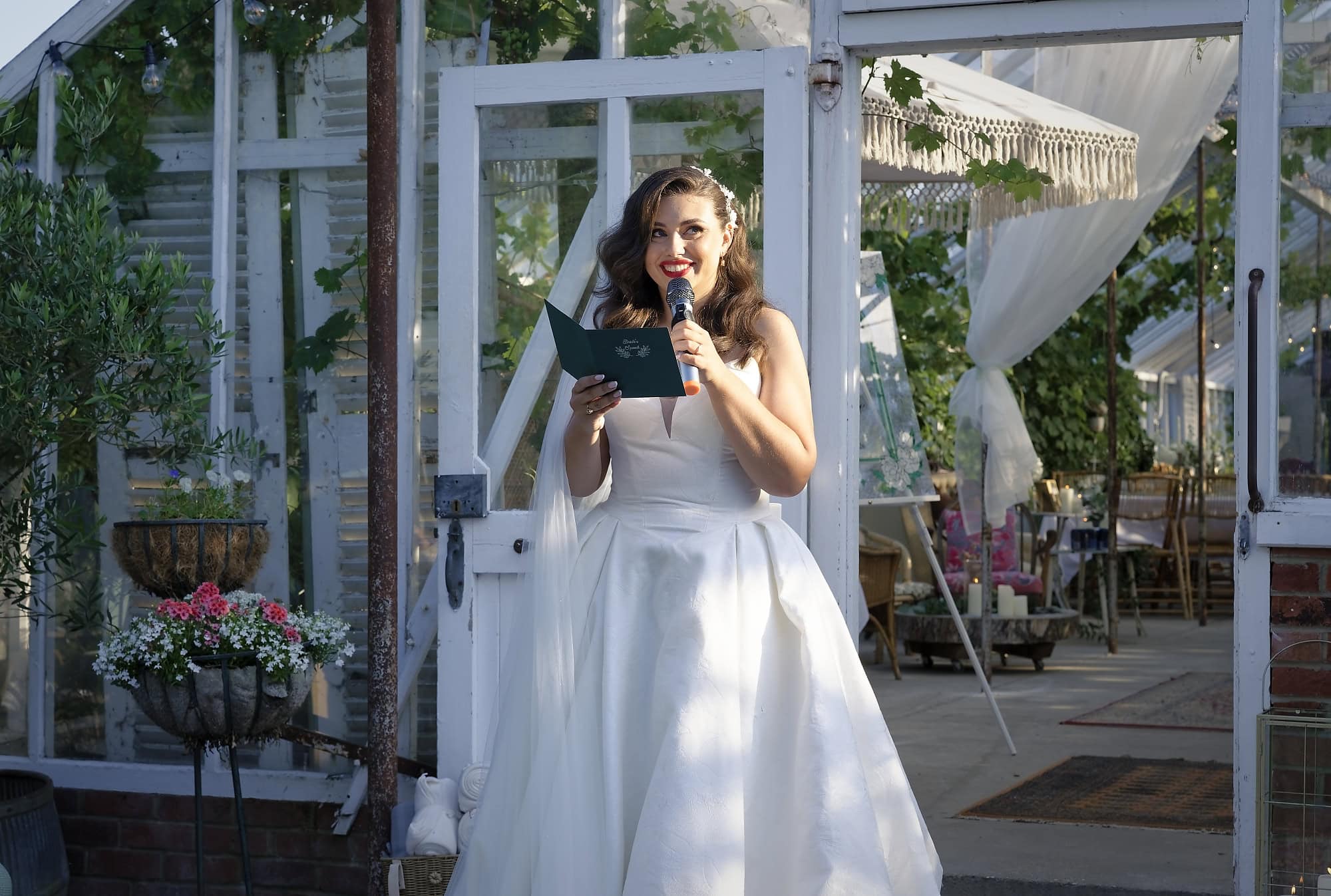 Bride giving her own wedding speech outside the glasshouse