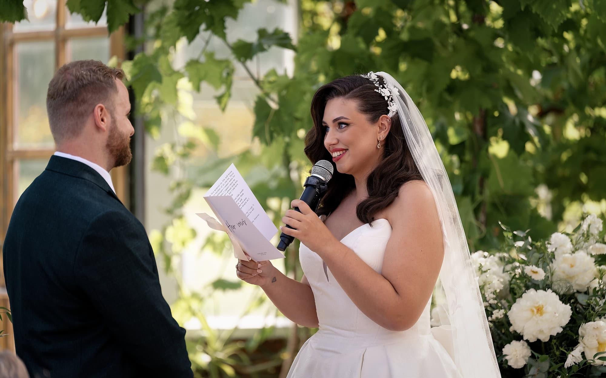 Bride reading her vows into a microphone during the ceremony