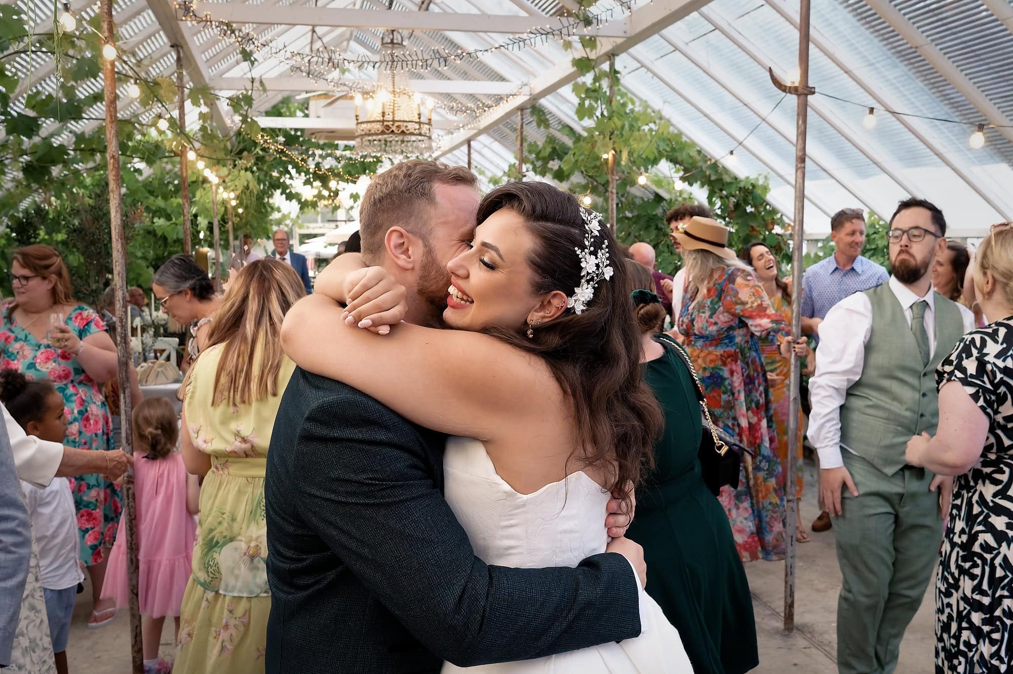 Bride and groom sharing a hug on the busy evening dancefloor
