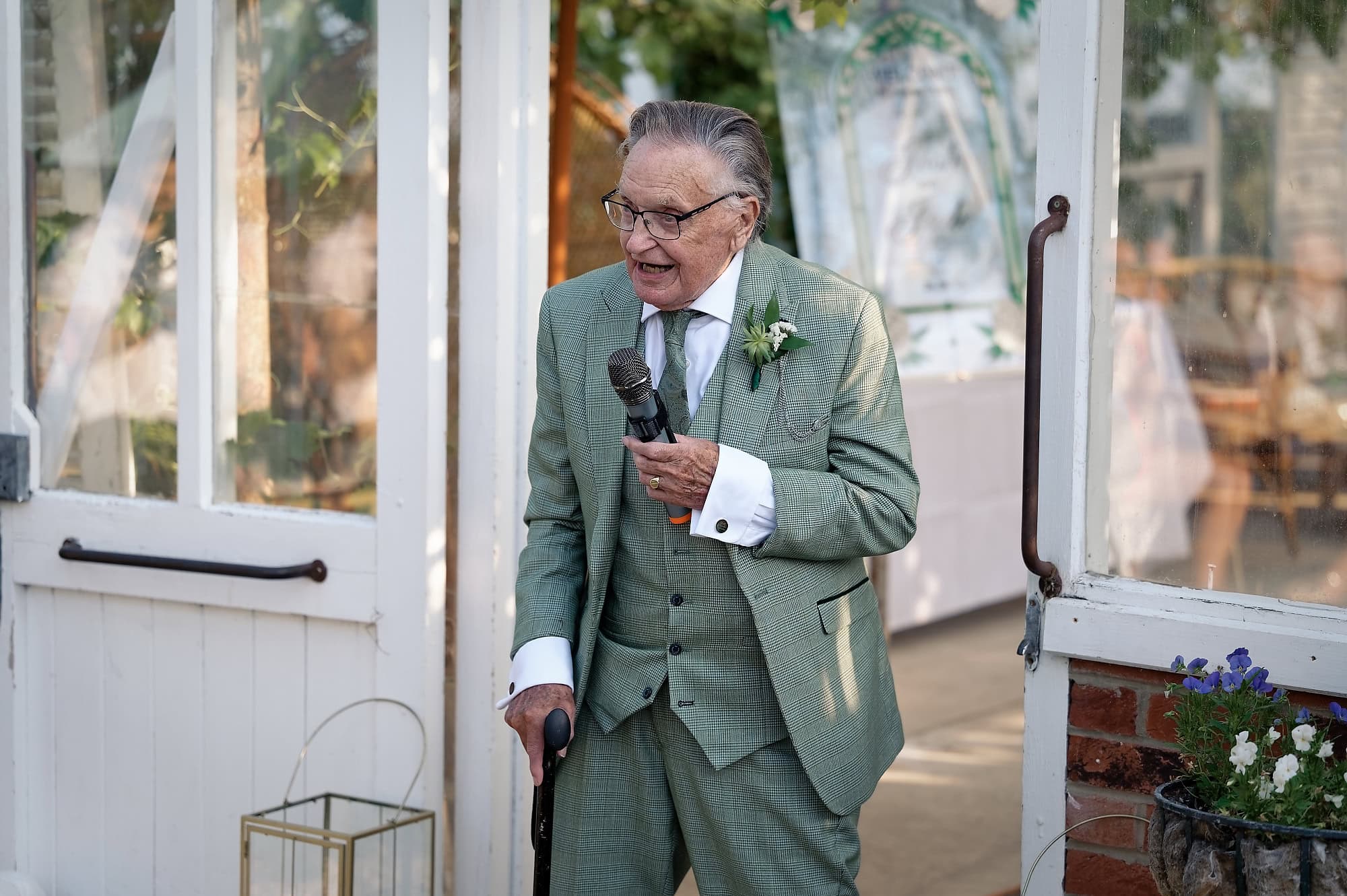 Bride's grandad giving a speech into the microphone