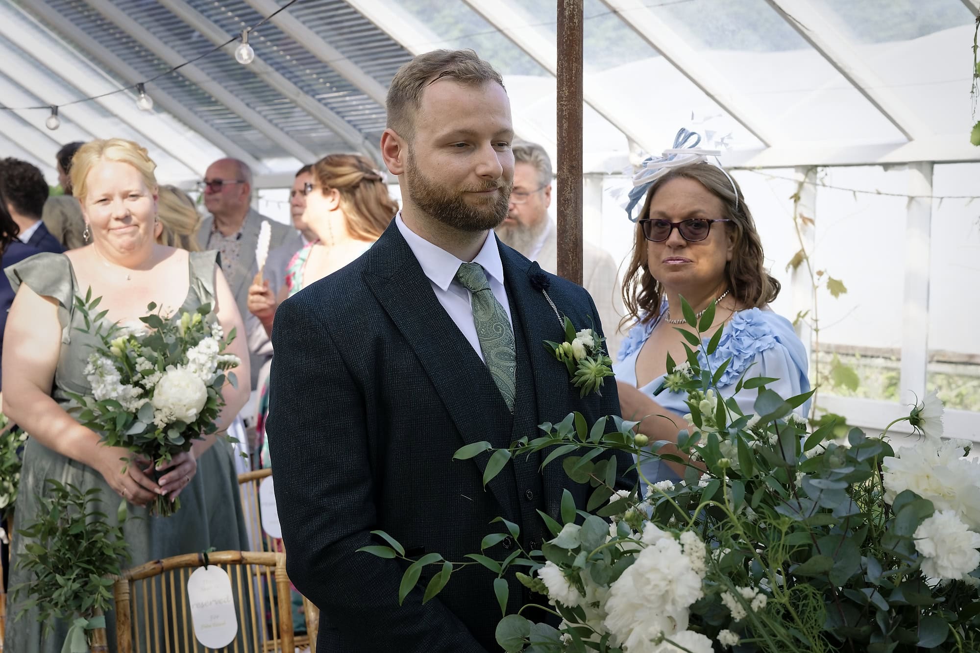 Groom waiting inside the vine-covered glasshouse at Gooseberry House before the ceremony