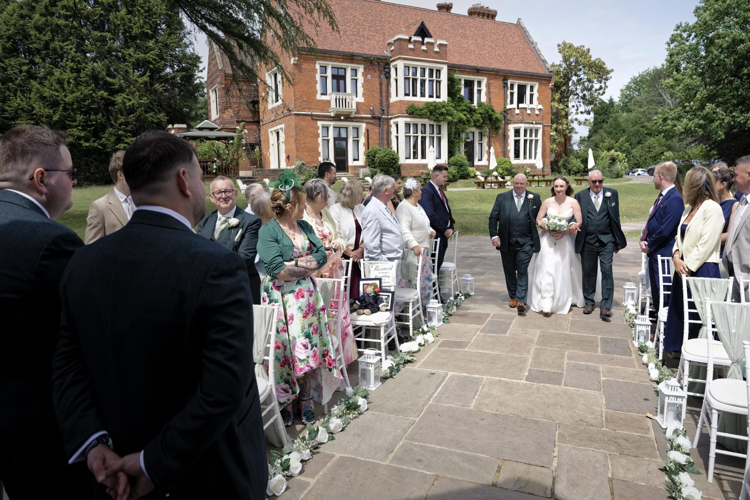 Bride walking down the aisle with her father and stepfather at Highley Manor