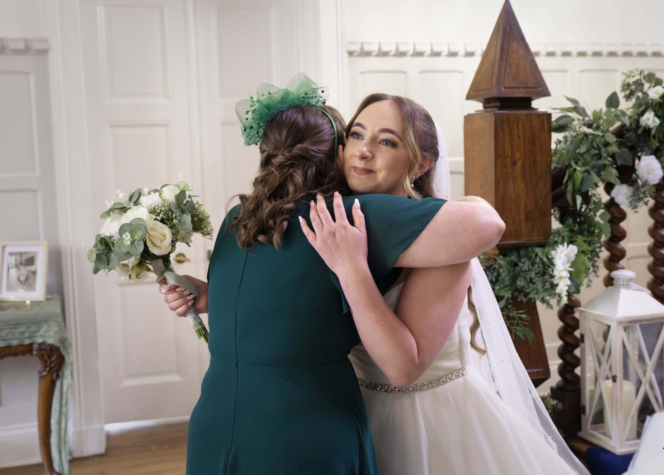Bride embracing a bridesmaid before the ceremony at Highley Manor