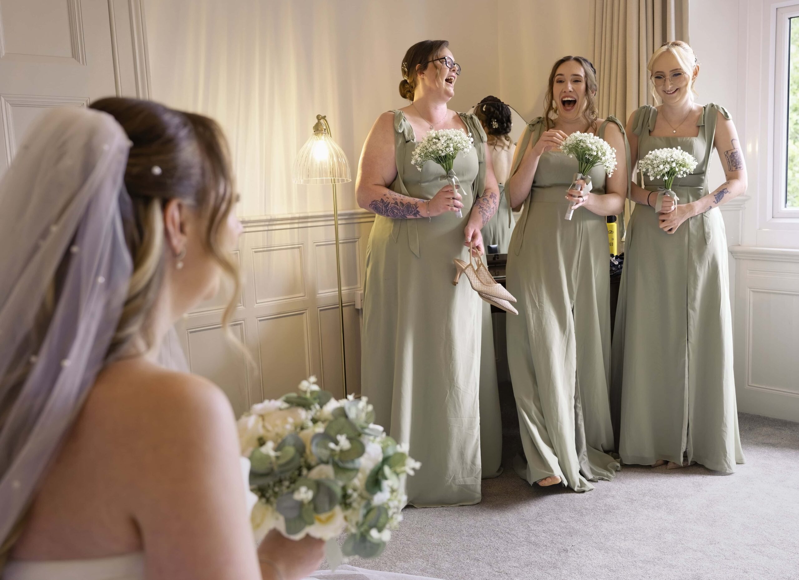 Bridesmaids reacting emotionally as they see the bride in her dress at Highley Manor