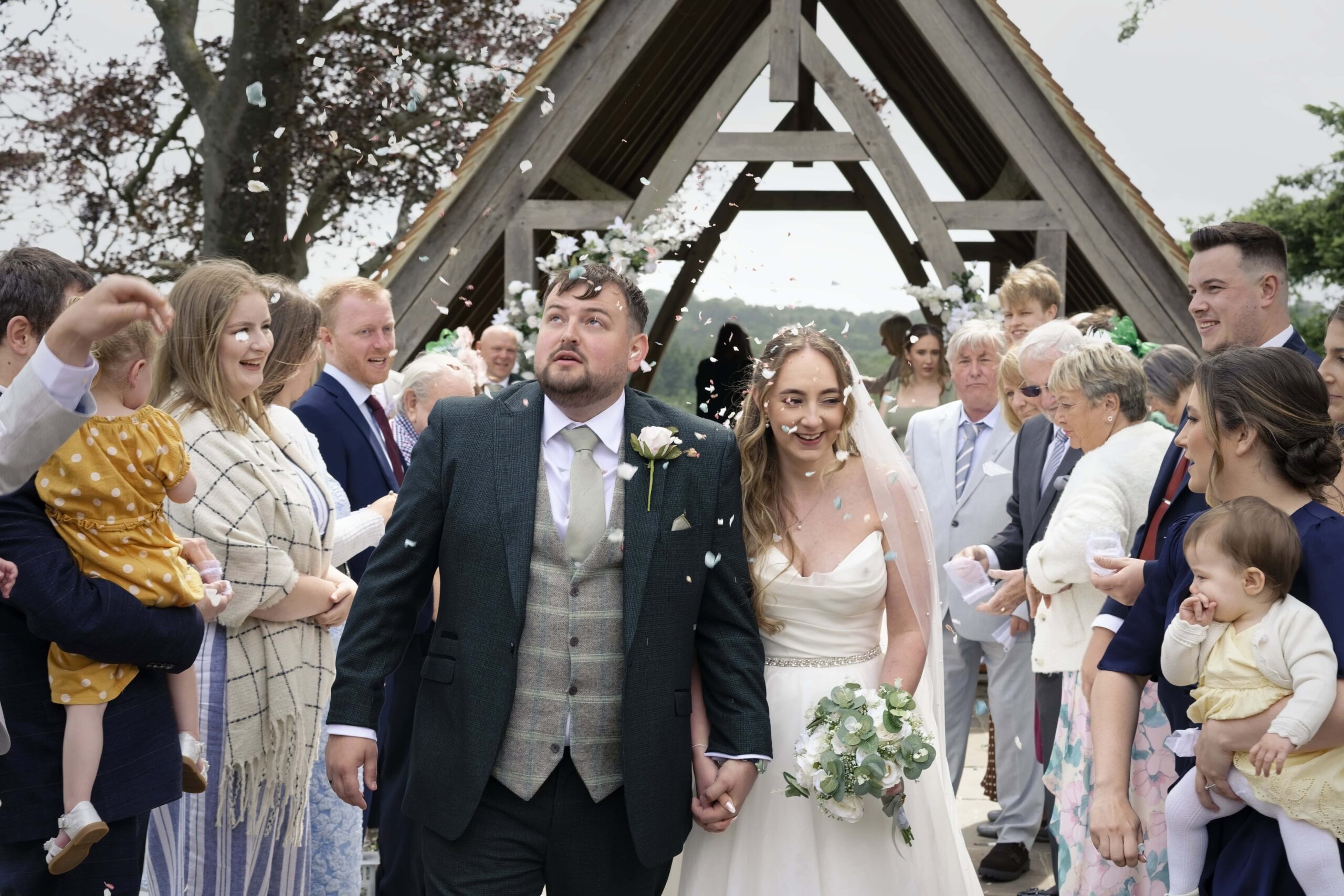 Newlyweds walking through confetti after their ceremony at Highley Manor