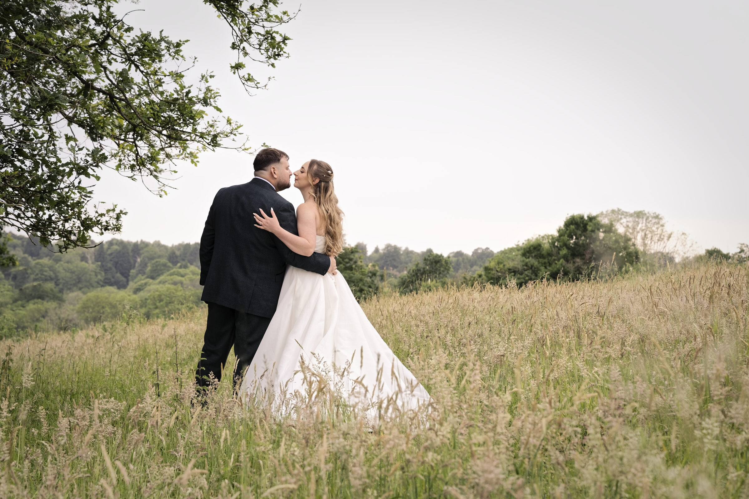Bride and groom embracing in a wildflower meadow in the grounds of Highley Manor