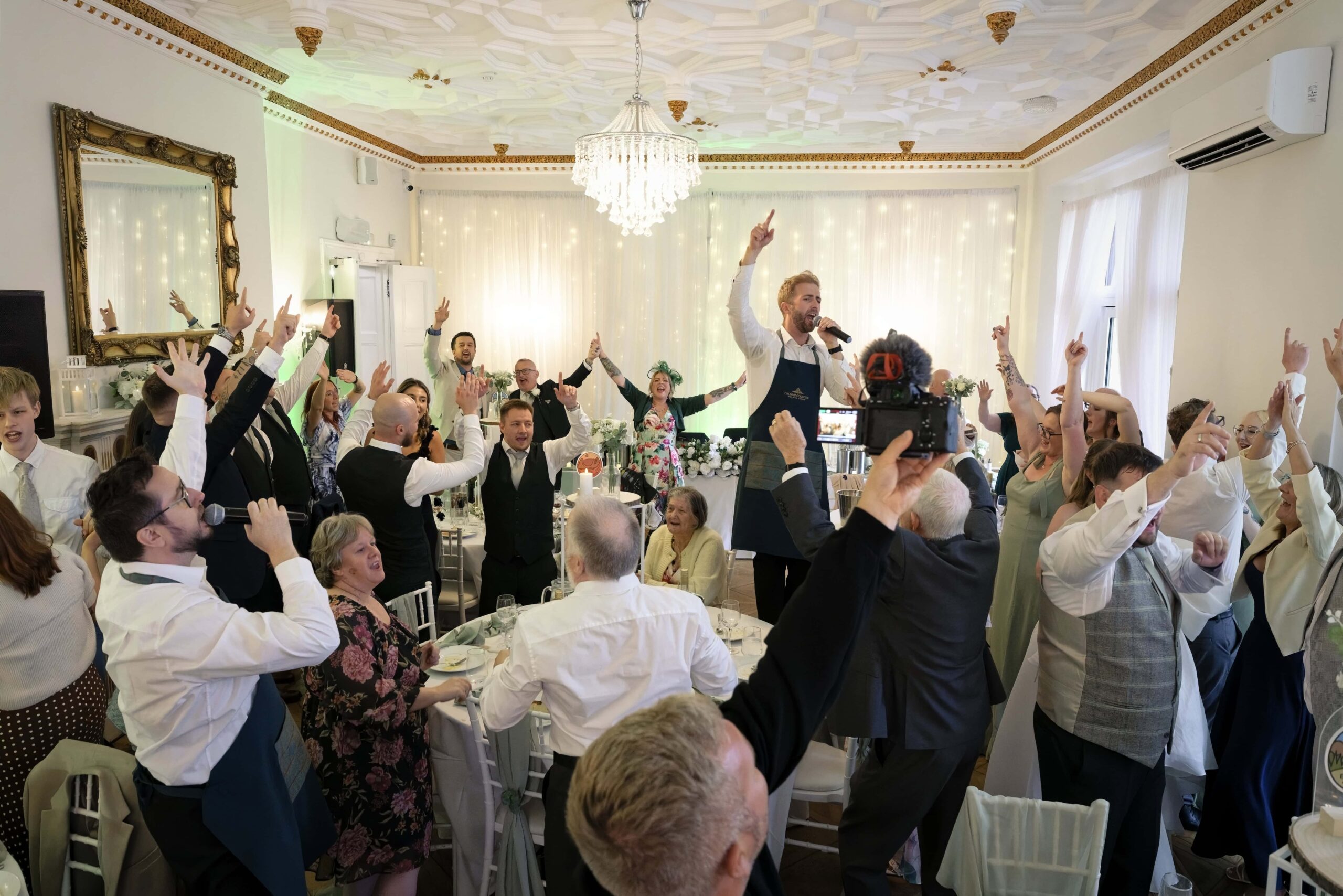 Guests cheering as the surprise singing waiters perform during dessert at Highley Manor