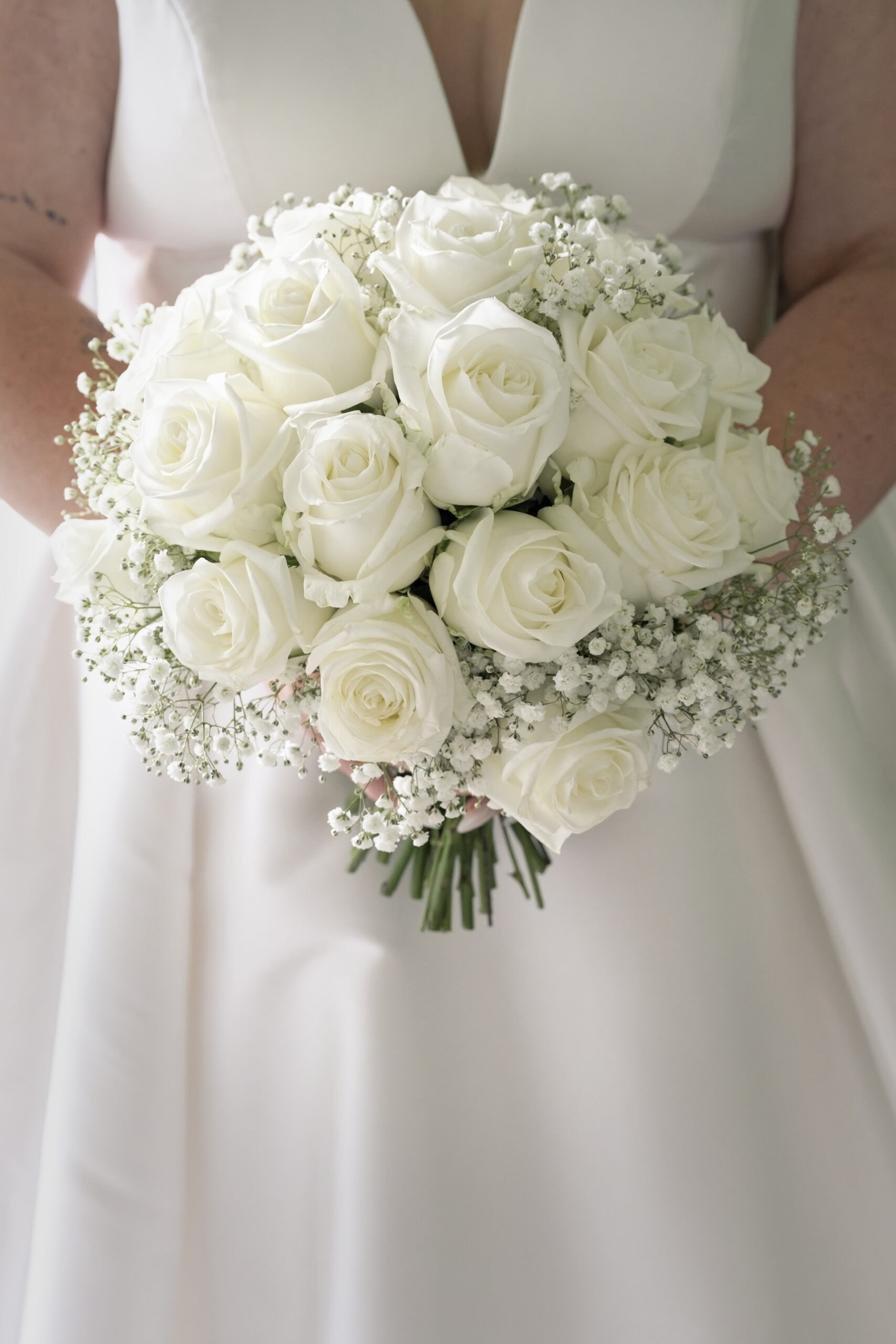 Bride holding her white rose and gypsophila bouquet