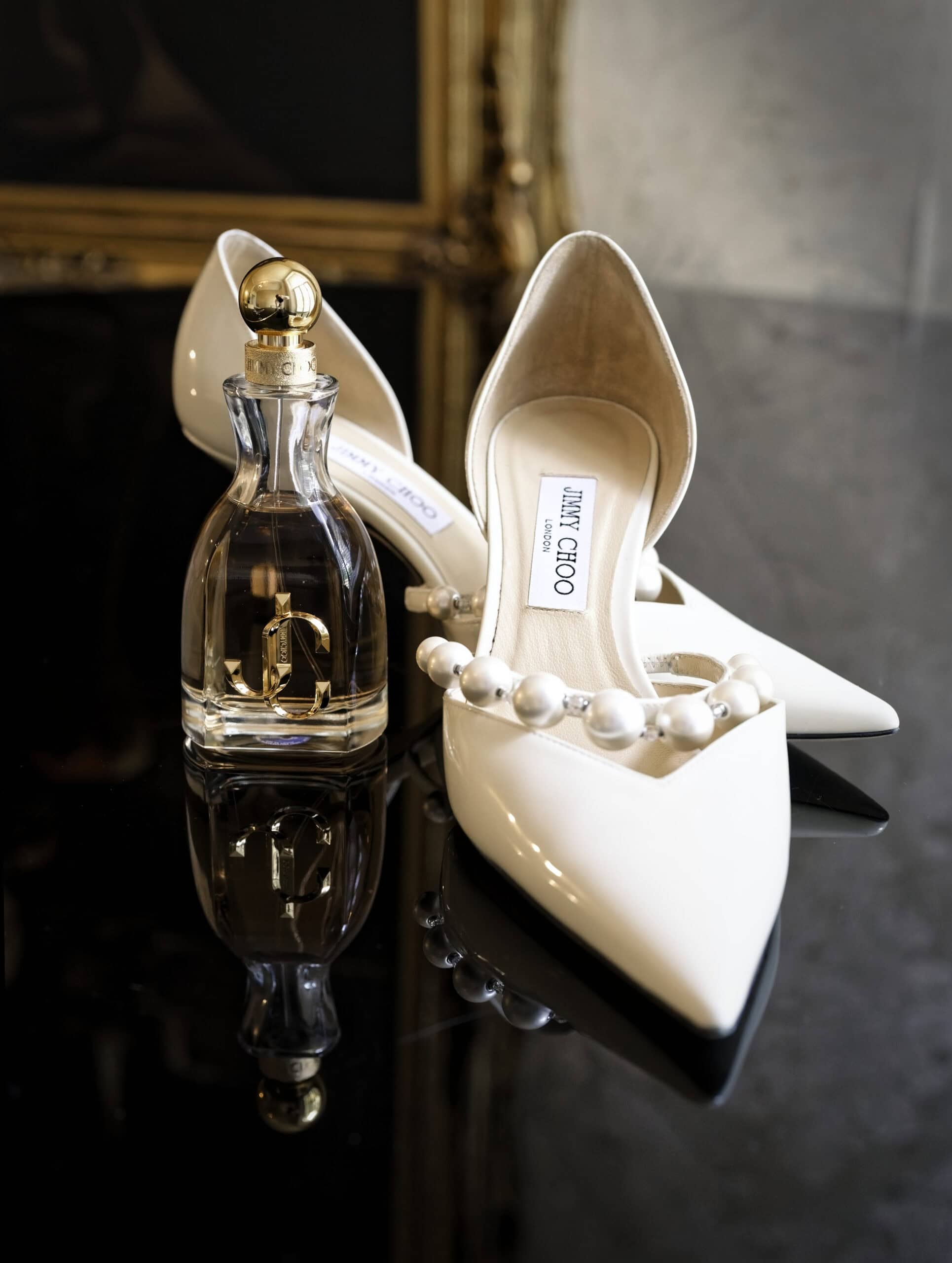 Ivory bridal shoes and perfume bottle detail shot before a Northbrook Park wedding
