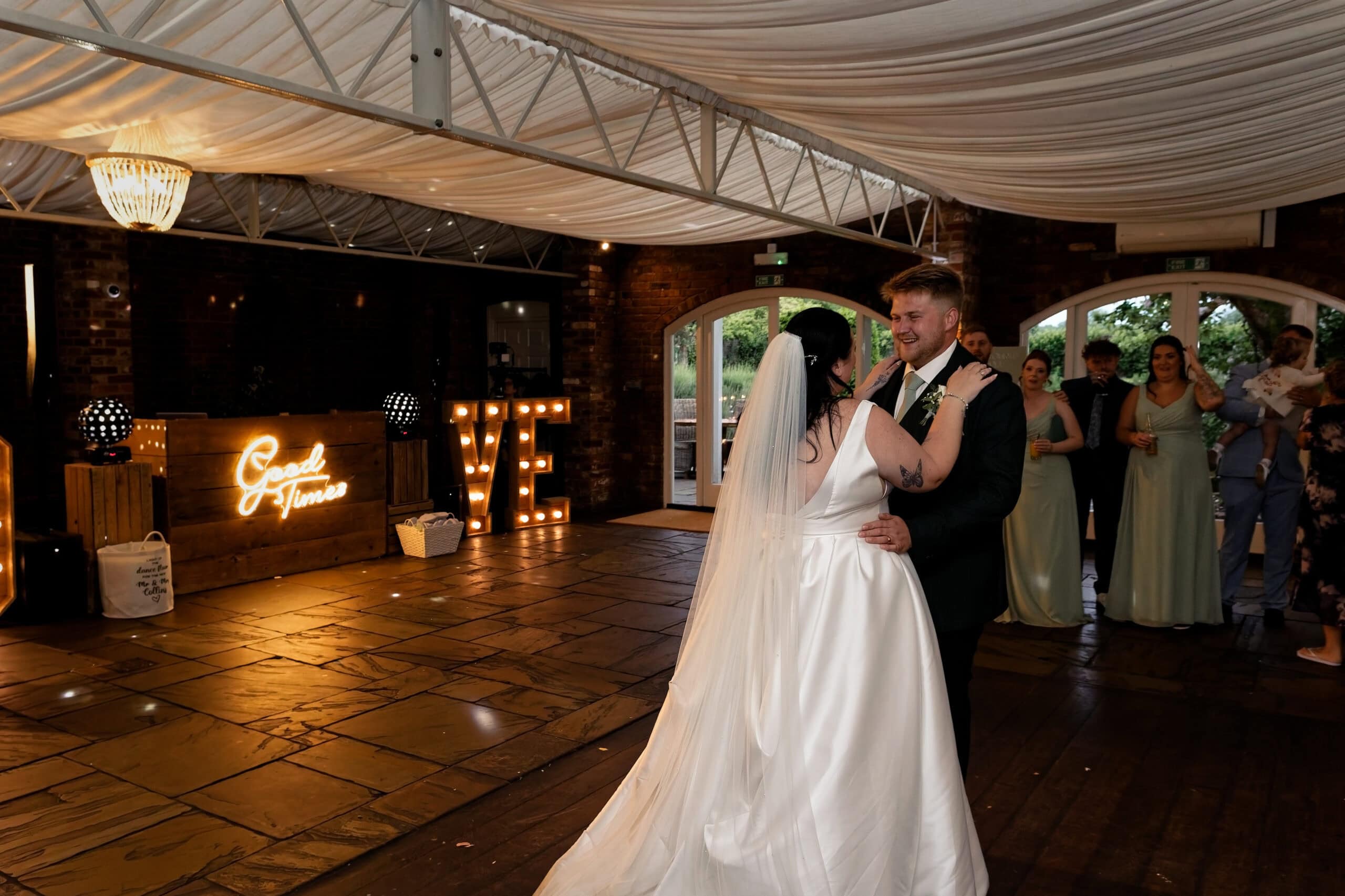 Bride watching from the doorway as the groom dances