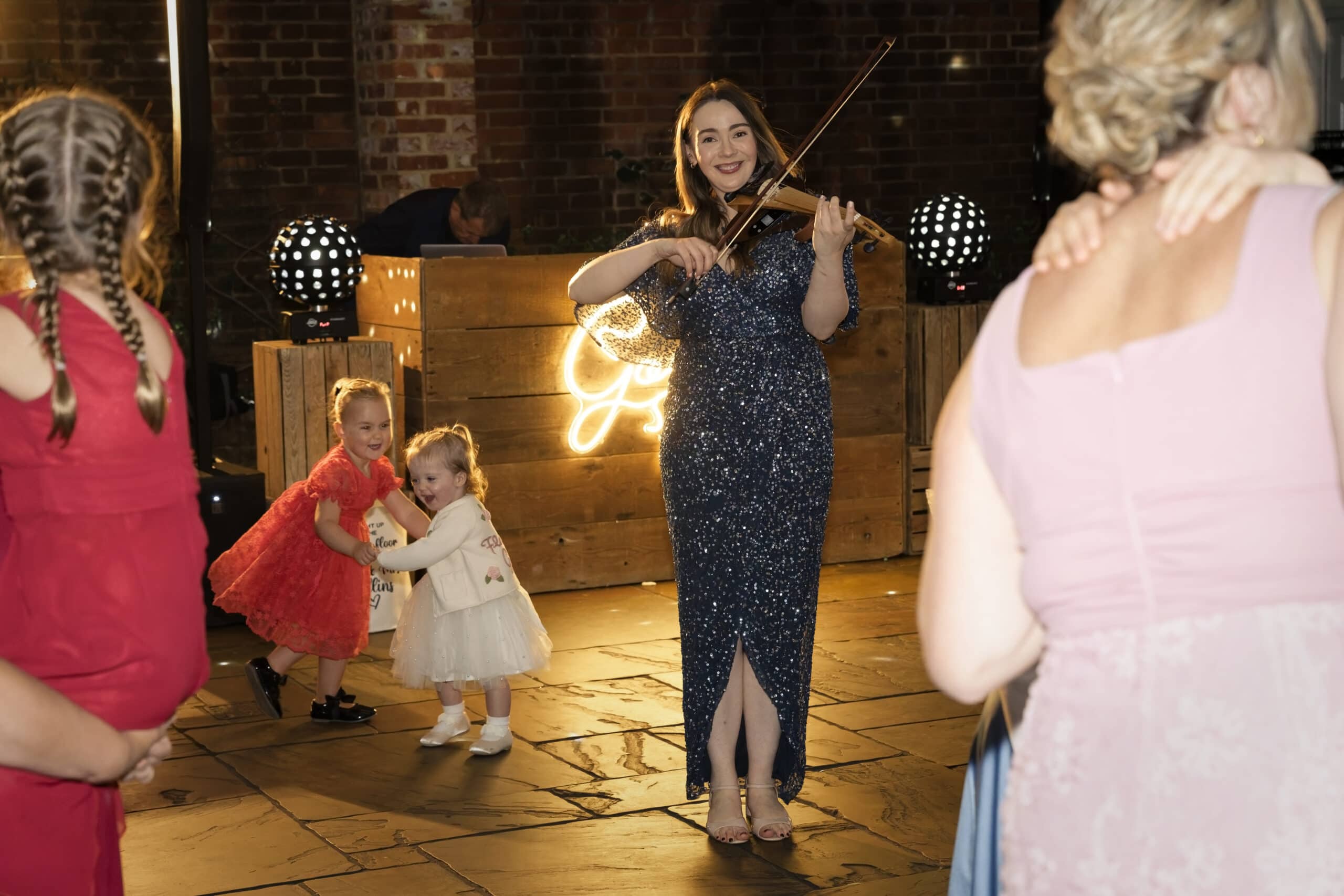 Children dancing alongside the evening violinist