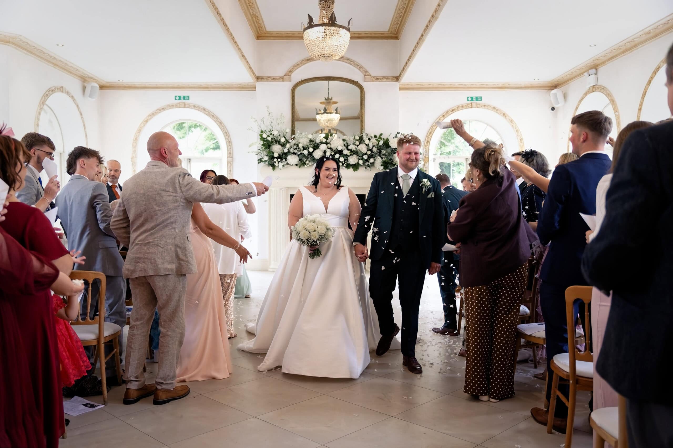 Bride and groom walking through confetti in the Vine Room
