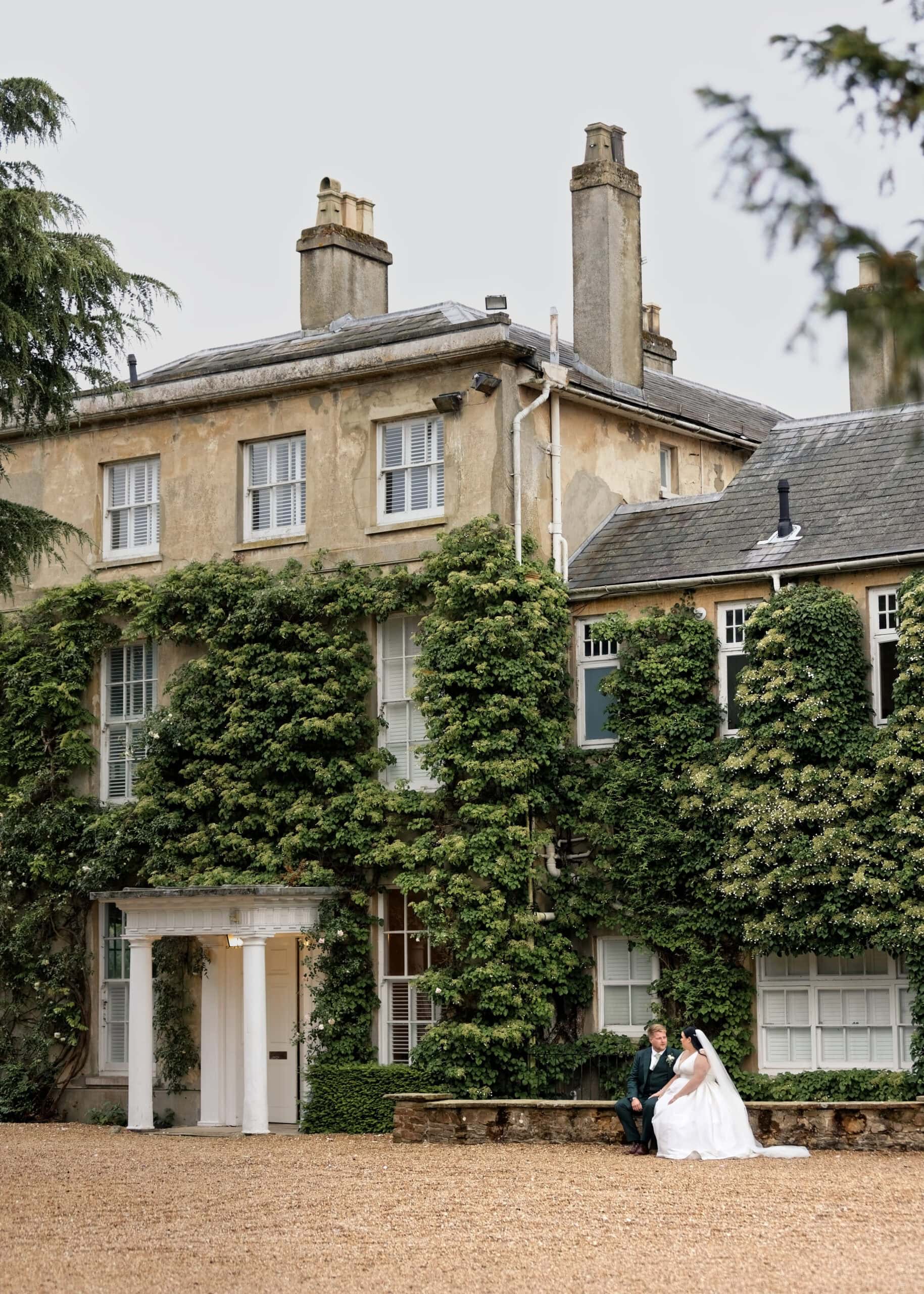 Bride and groom portrait outside the ivy-covered main house