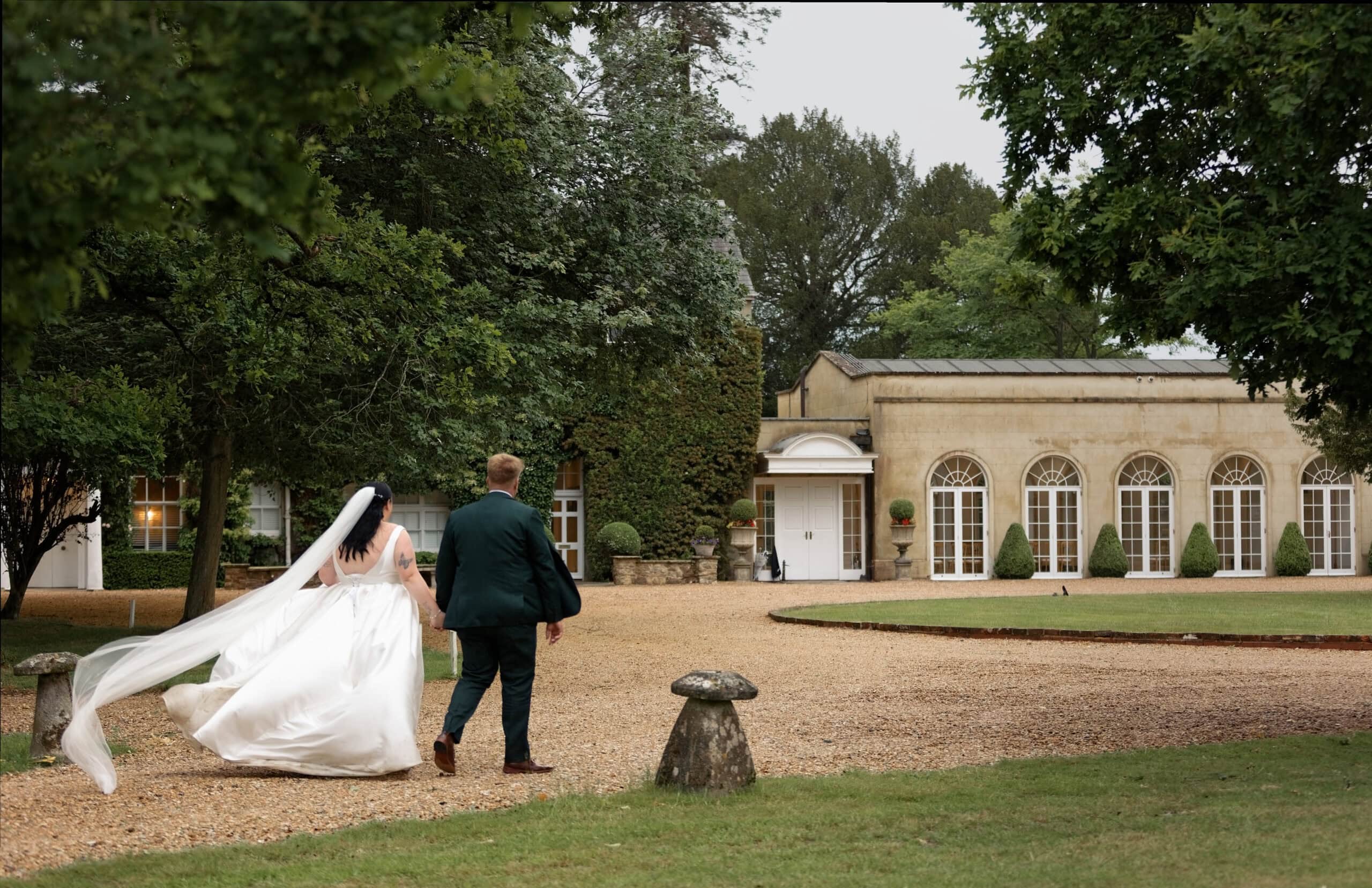 Bride and groom walking across the grounds at dusk