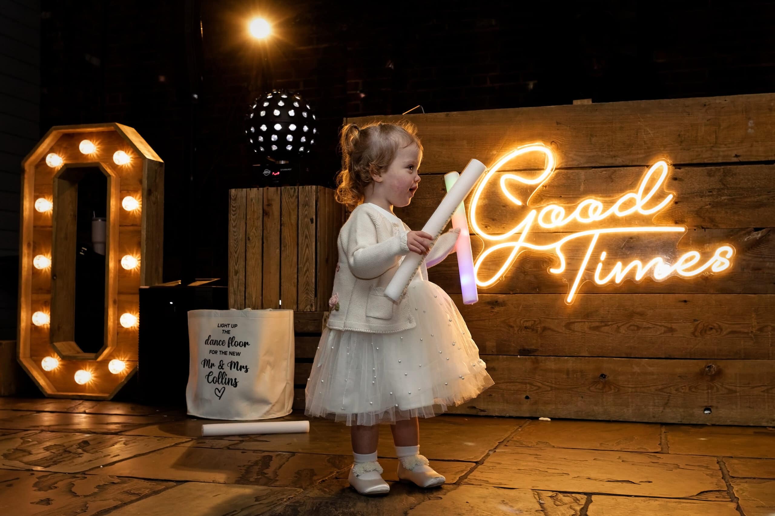 Flower girl dancing beside the neon sign