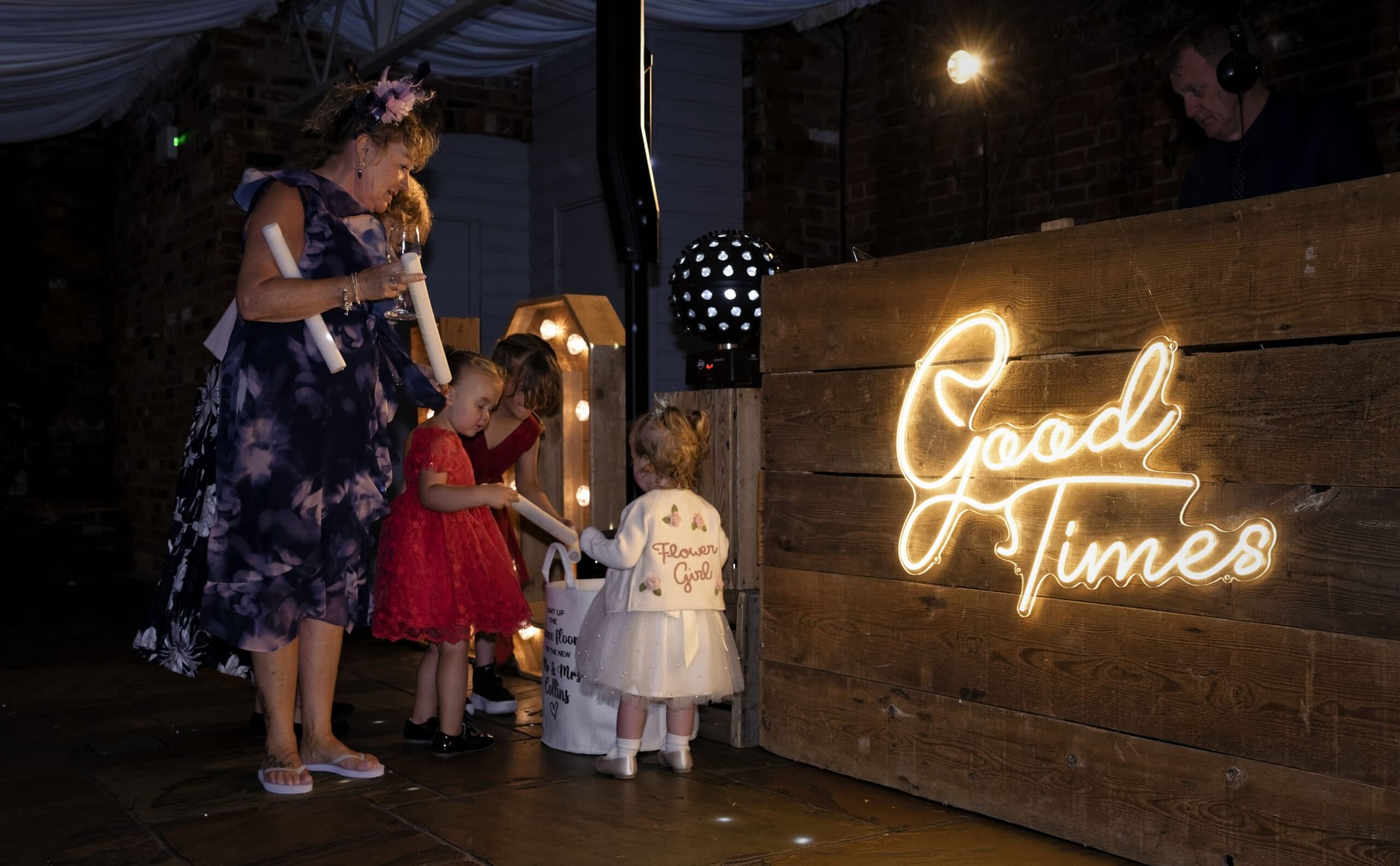 Flower girls dancing beside the Good Times neon sign