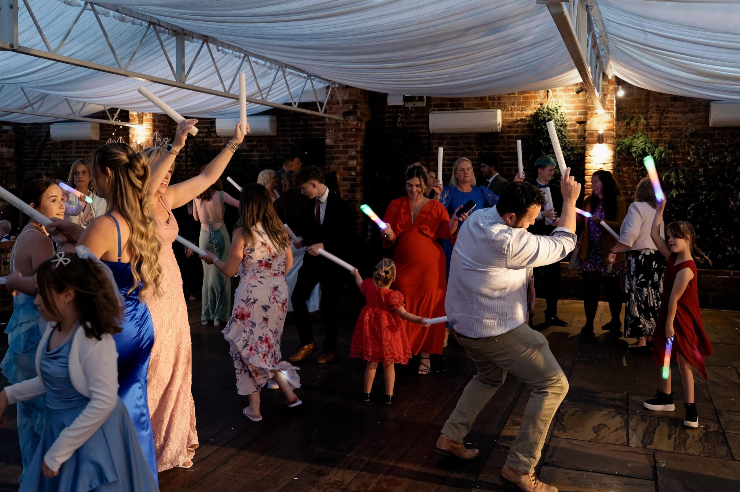 Guests dancing with glow sticks on the evening dance floor