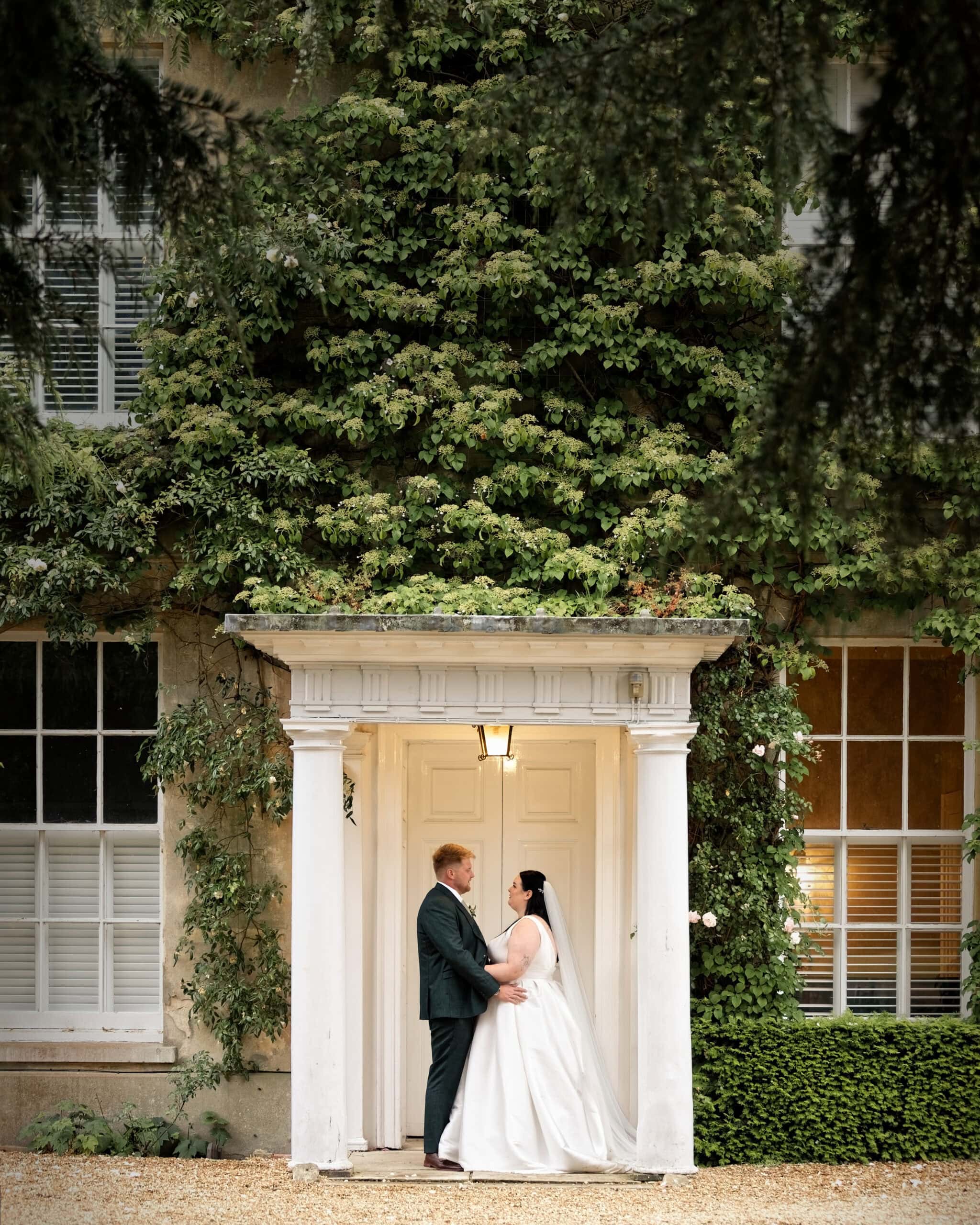 Couple portrait beneath the orangery colonnade at Northbrook Park
