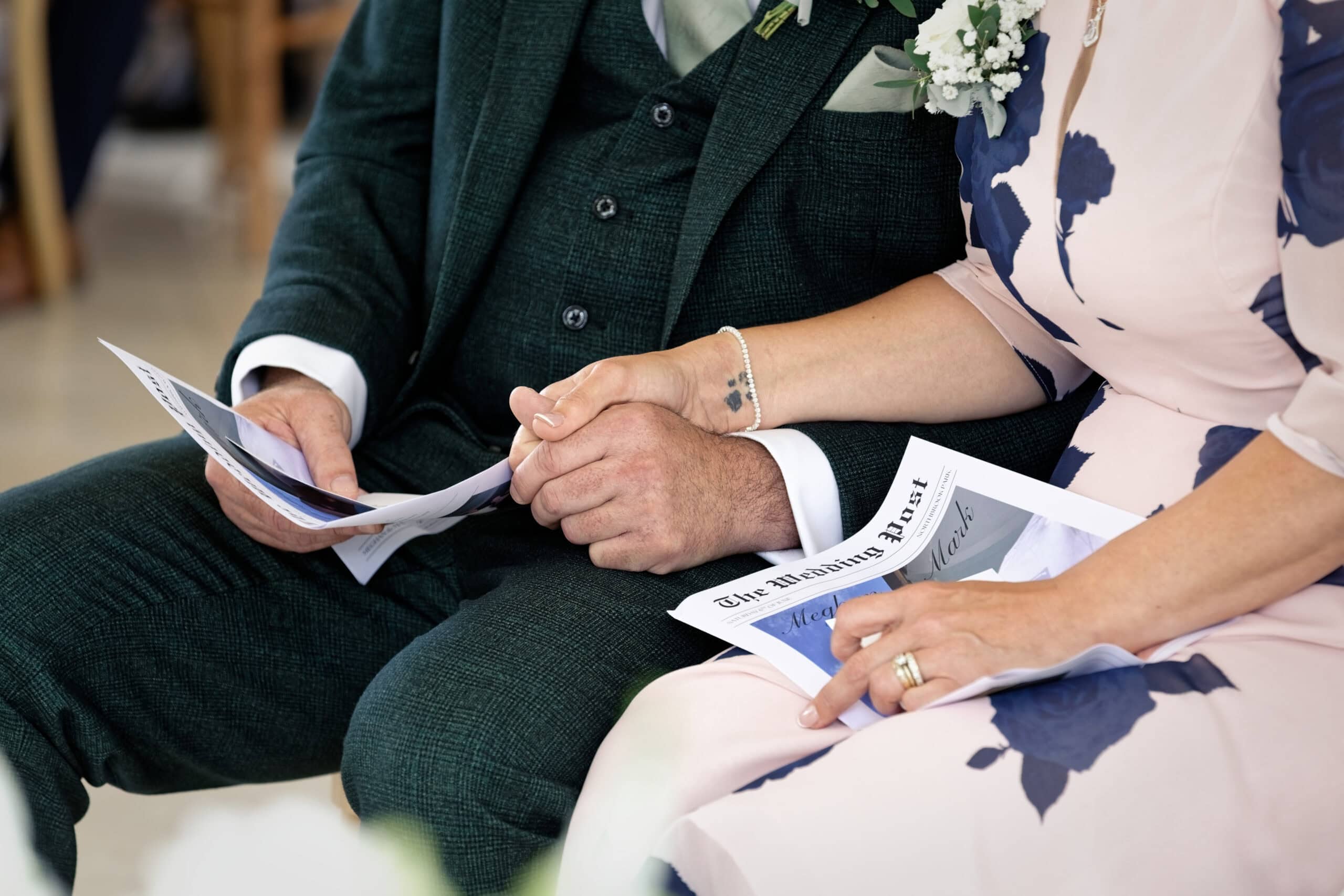 Bride's mum and dad holding hands as Meghan and Mark say their vows