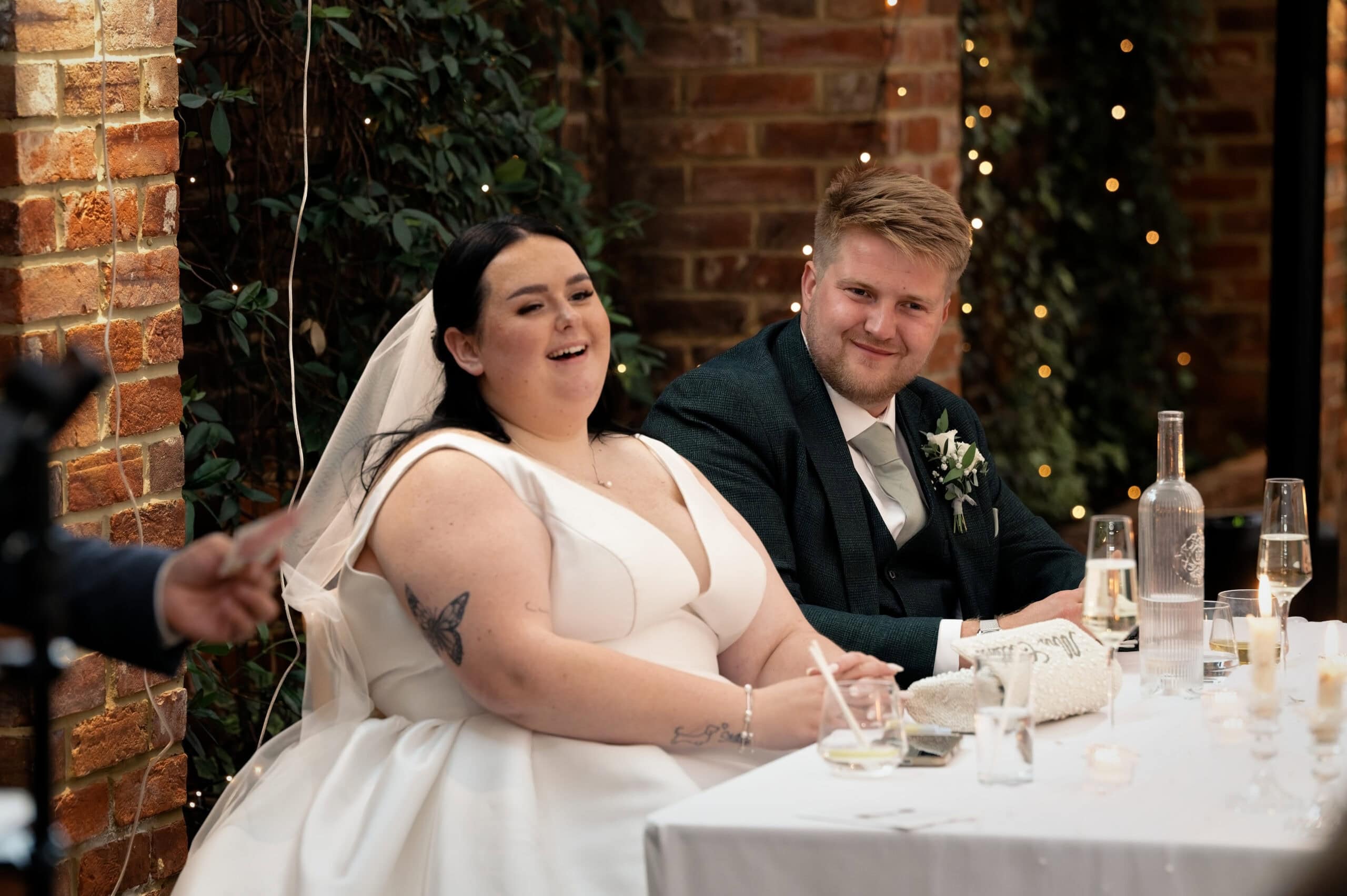 Bride and groom laughing at the top table